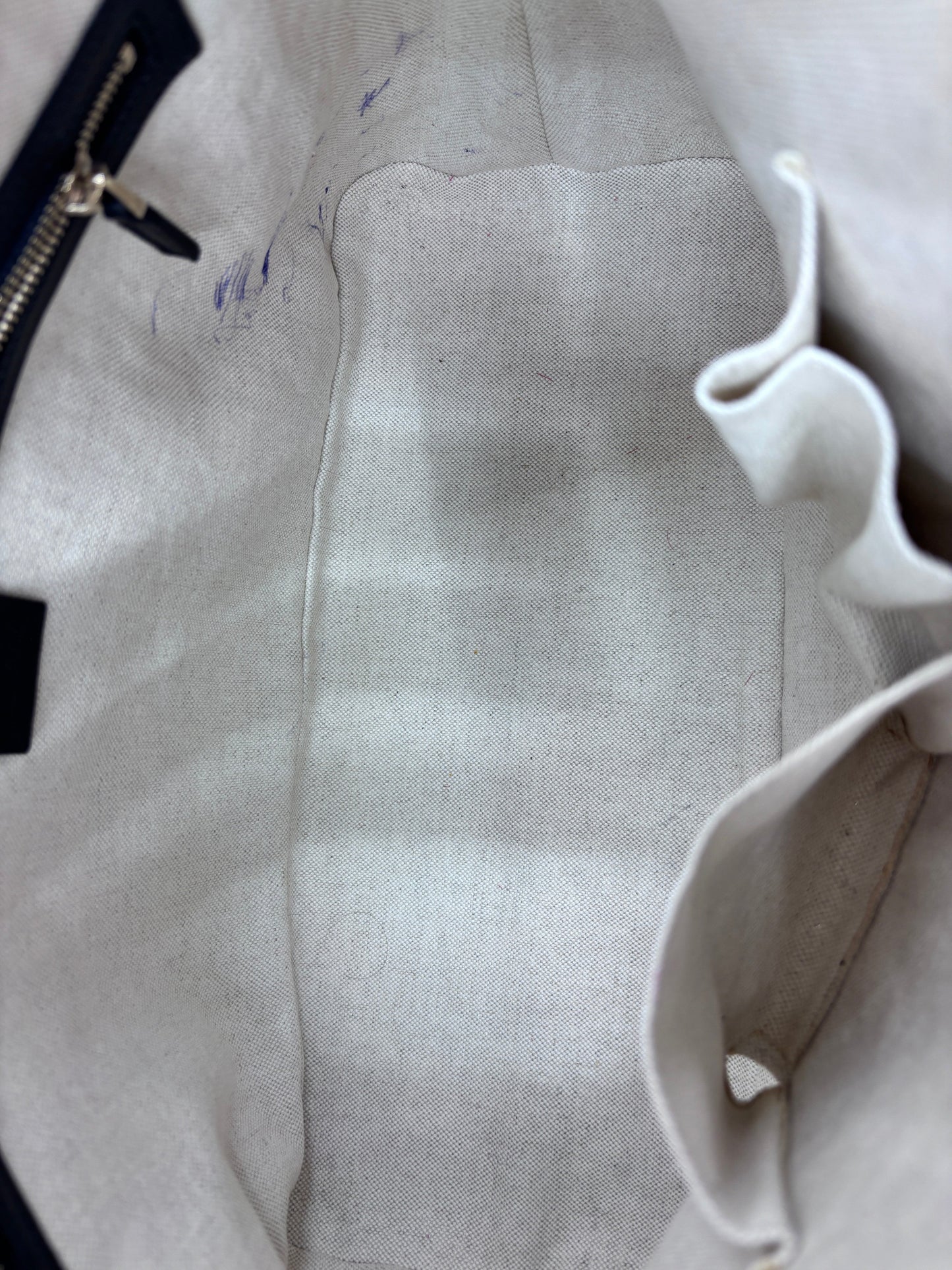 Interior of Posh Purse Co preloved Gucci Micro Guccissima bag featuring light beige fabric lining with pen marks