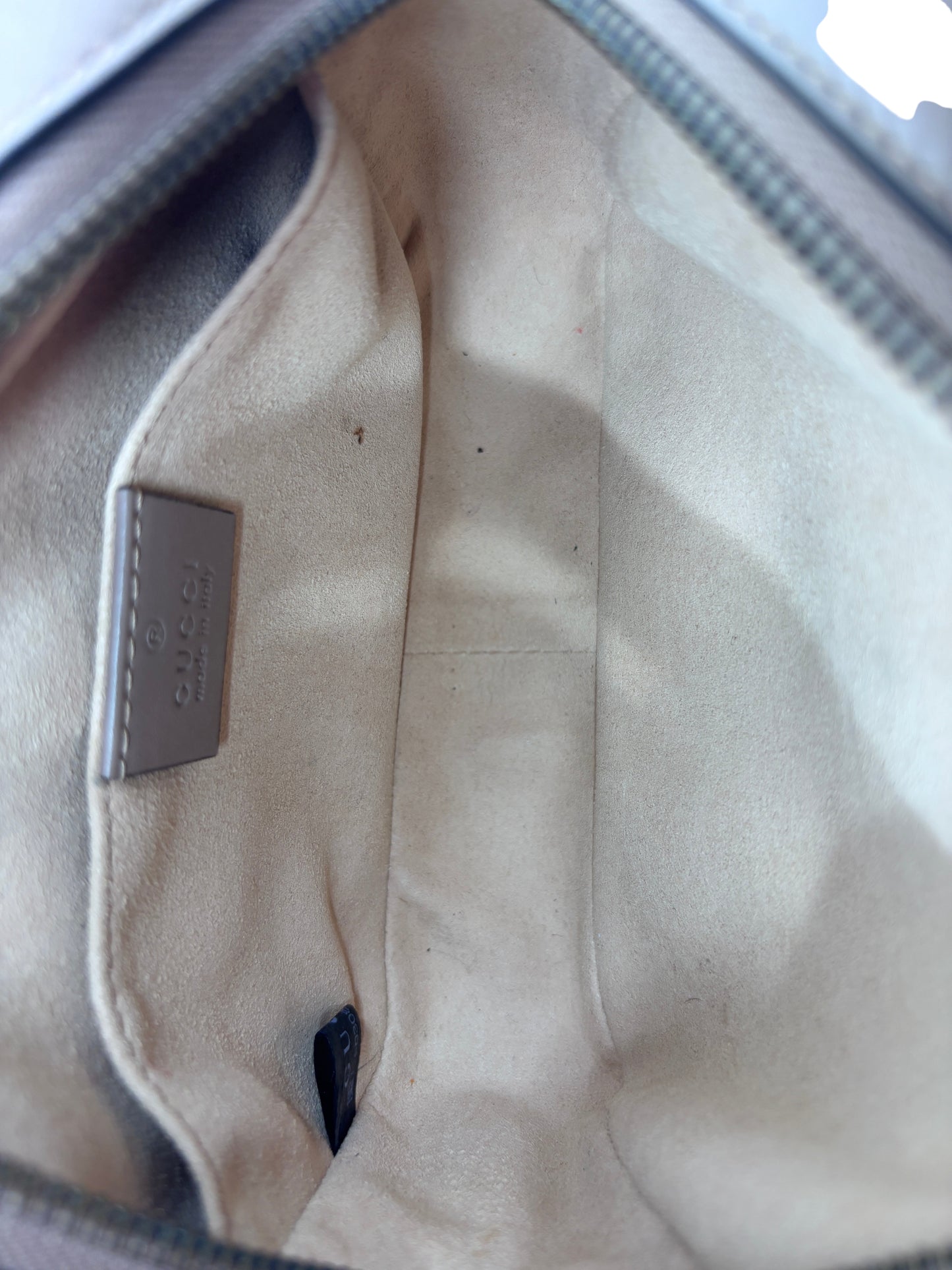 Interior of a Posh Purse Co. beige Gucci camera bag showing the fabric lining and leather brand tag
