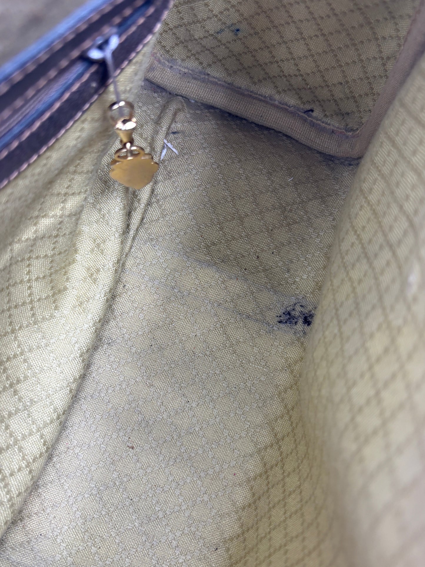 Interior of a vintage Gucci Boston bag from Posh Purse Co showing the beige diamond pattern lining and minor staining.