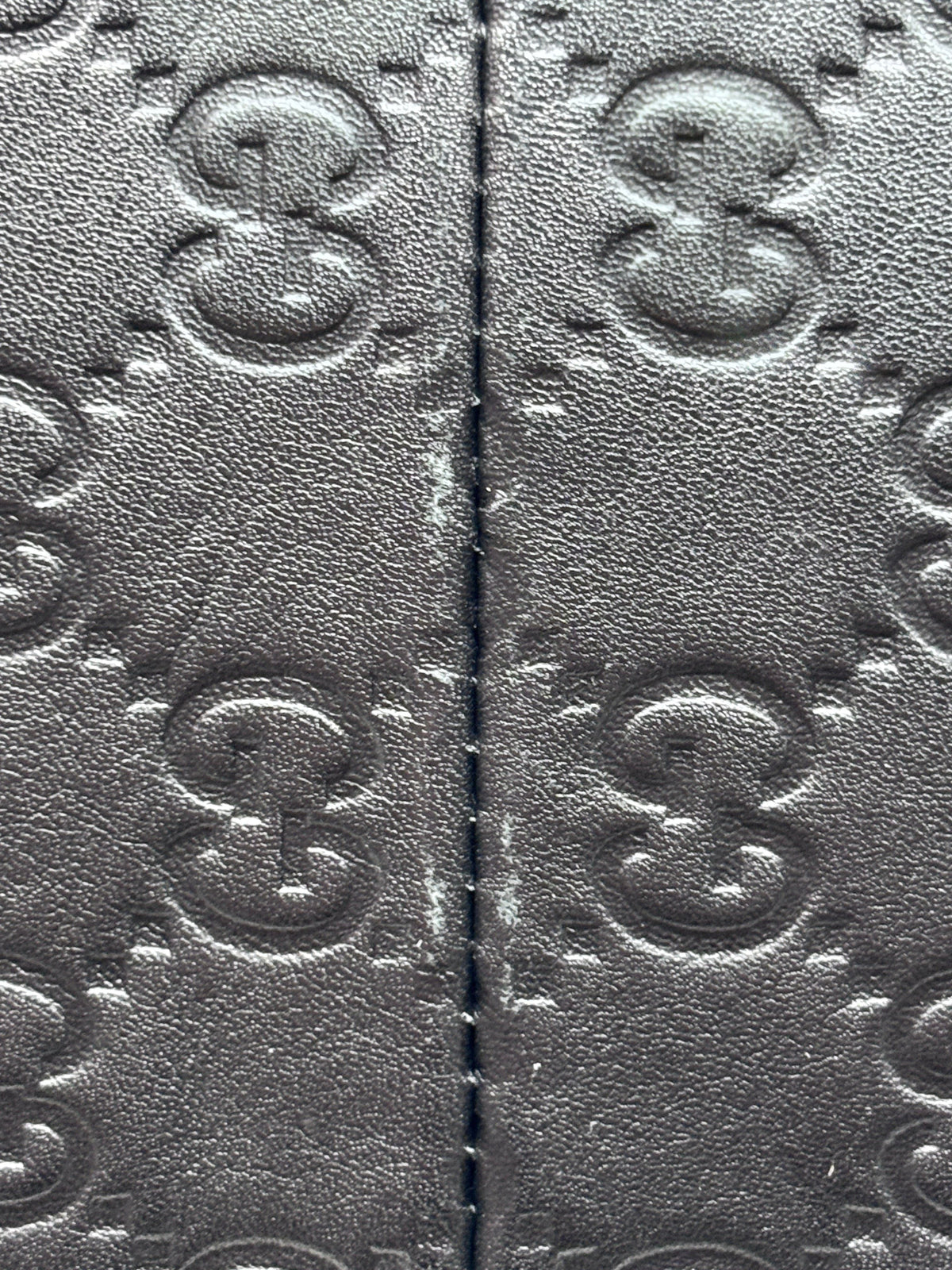 Close-up of black embossed leather on a Posh Purse Co. Gucci Horsebit 1955 hobo bag showing the iconic GG pattern.