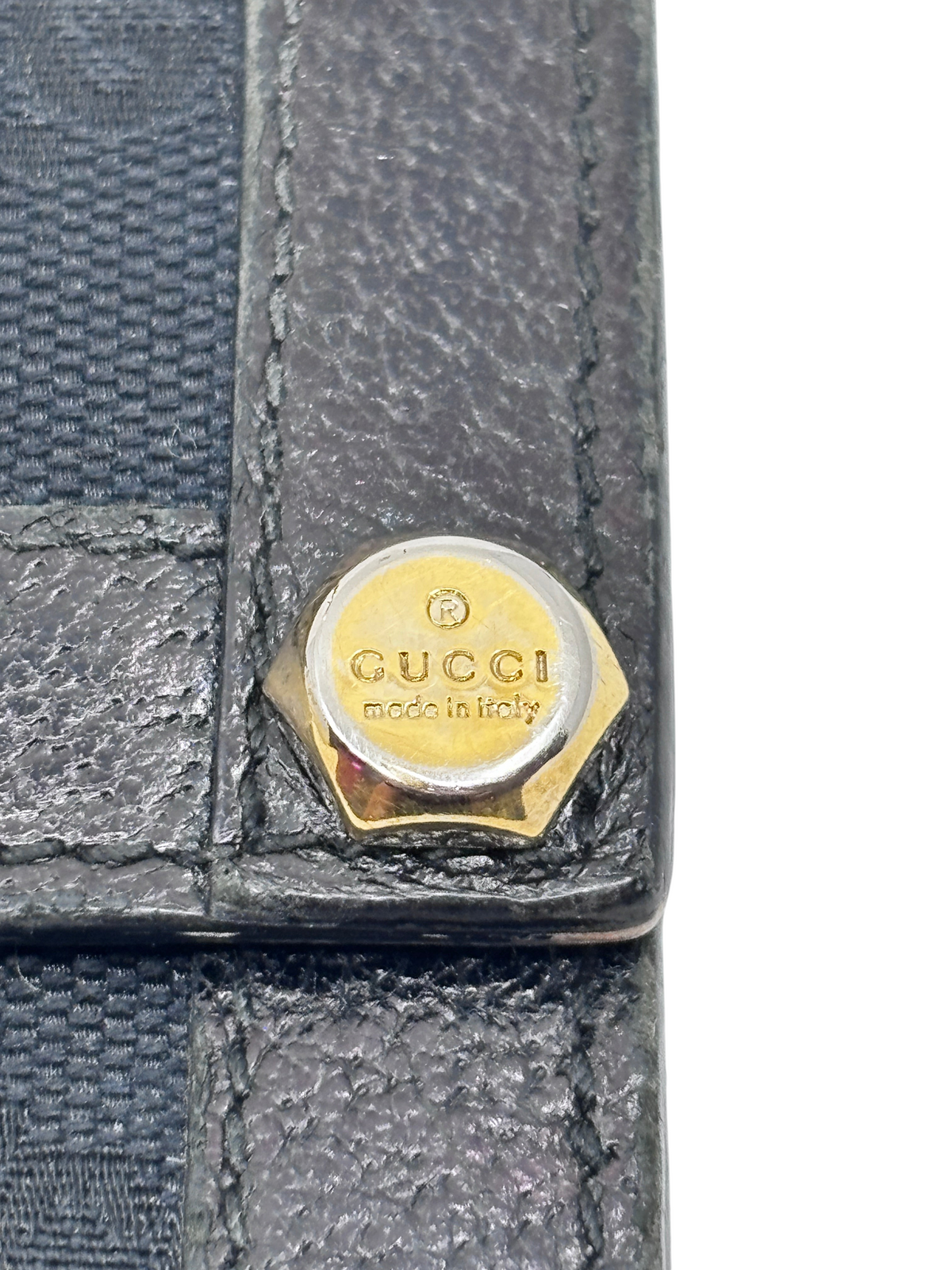 Posh Purse Co. preloved Gucci continental wallet featuring a gold-tone logo hardware detail on black textured fabric.
