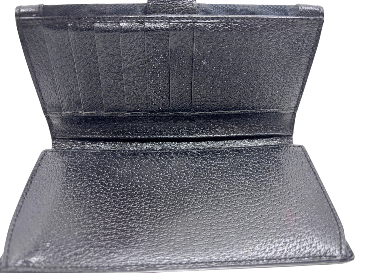 Interior view of a preloved Posh Purse Co. Gucci black continental wallet featuring multiple card slots.
