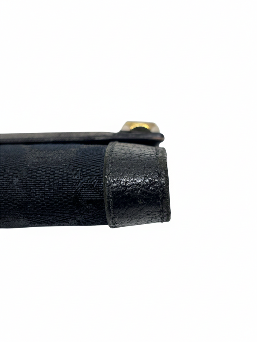 Posh Purse Co. preloved black Gucci continental wallet showing detailed view of the textured leather side trim