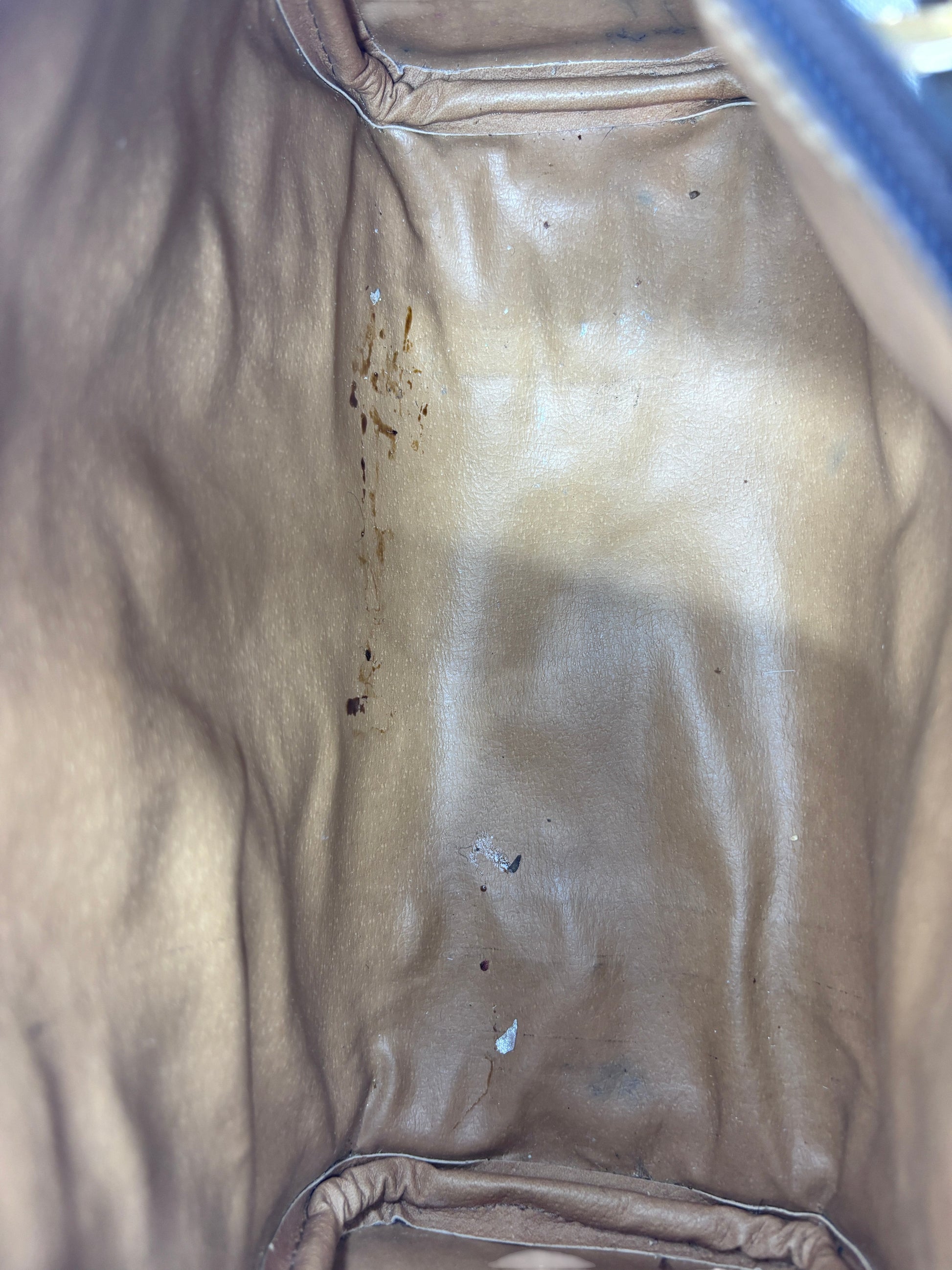 Interior view of a vintage Posh Purse Co Gucci Boston bag showing tan leather lining with signs of wear and staining.