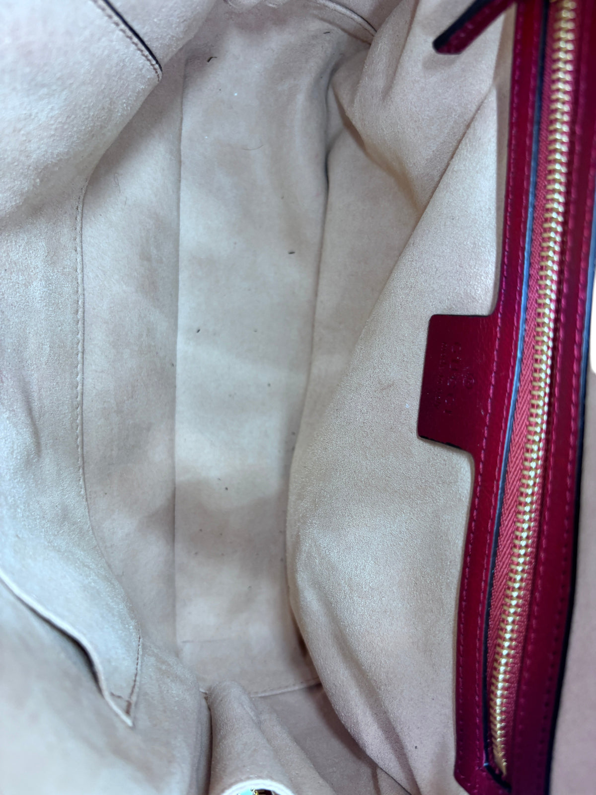 Interior view of a preloved Posh Purse Co Gucci camera bag featuring a beige suede lining and red leather trim.