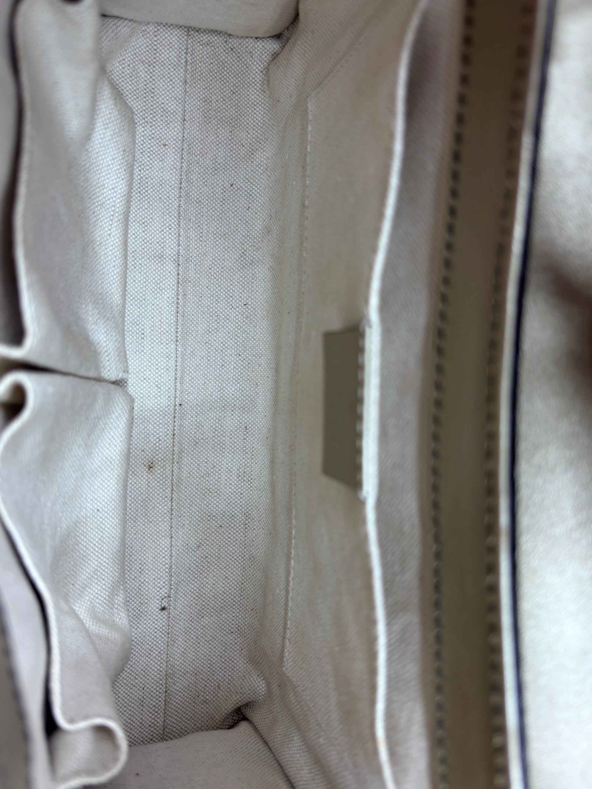 Interior of Posh Purse Co. Gucci Guccissima Emily bag featuring a clean beige fabric lining and organizational pockets.
