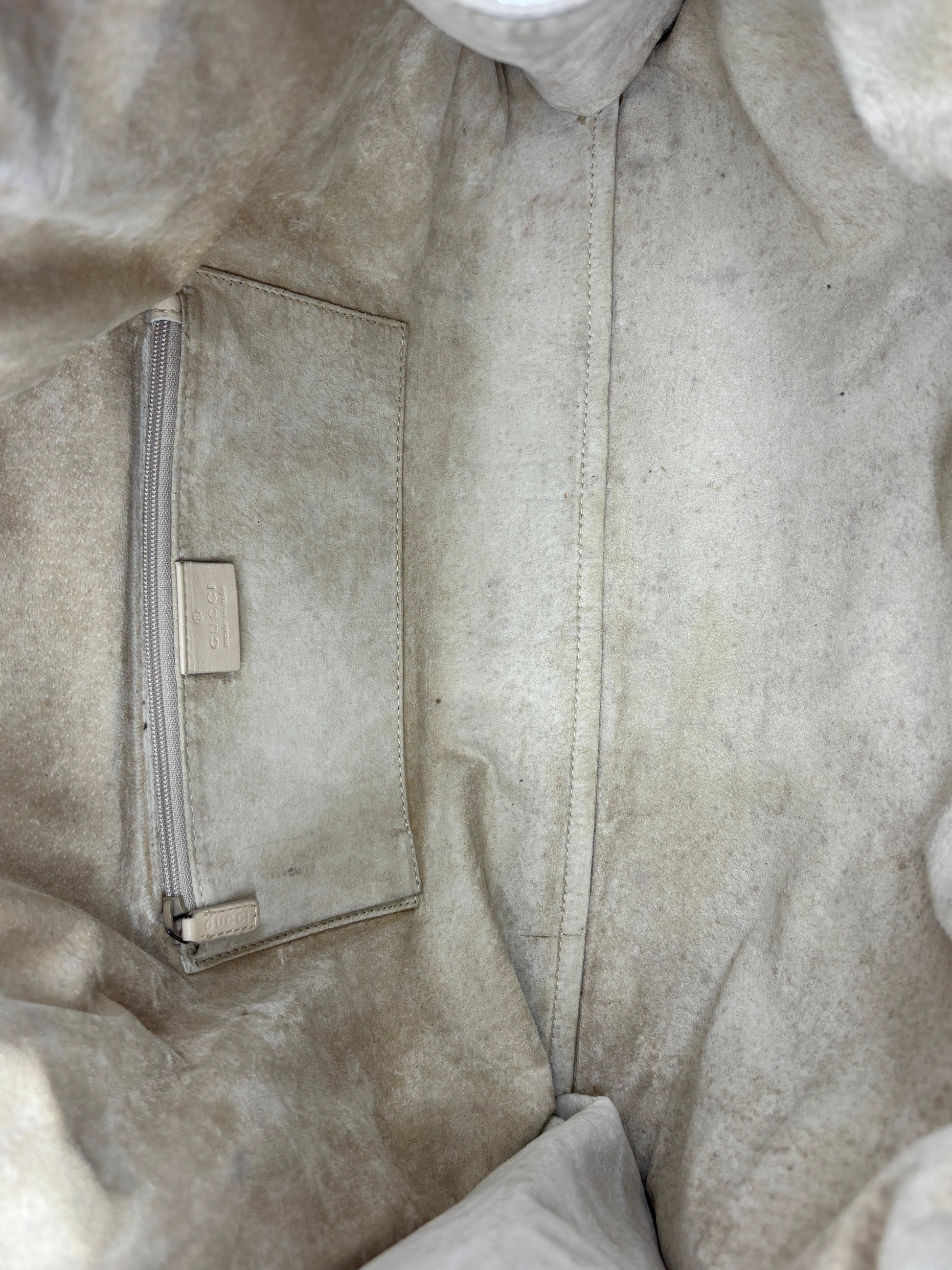Interior of a Posh Purse Co Gucci Tom Ford era hobo bag featuring a beige suede lining and a zippered leather pocket.