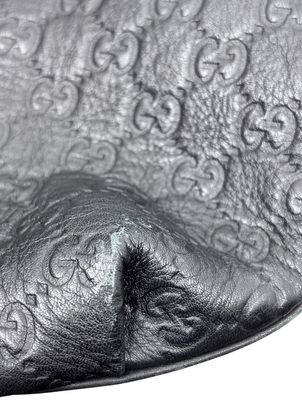 Close-up of black leather Gucci Horsebit 1955 hobo bag with embossed GG logo pattern from Posh Purse Co.