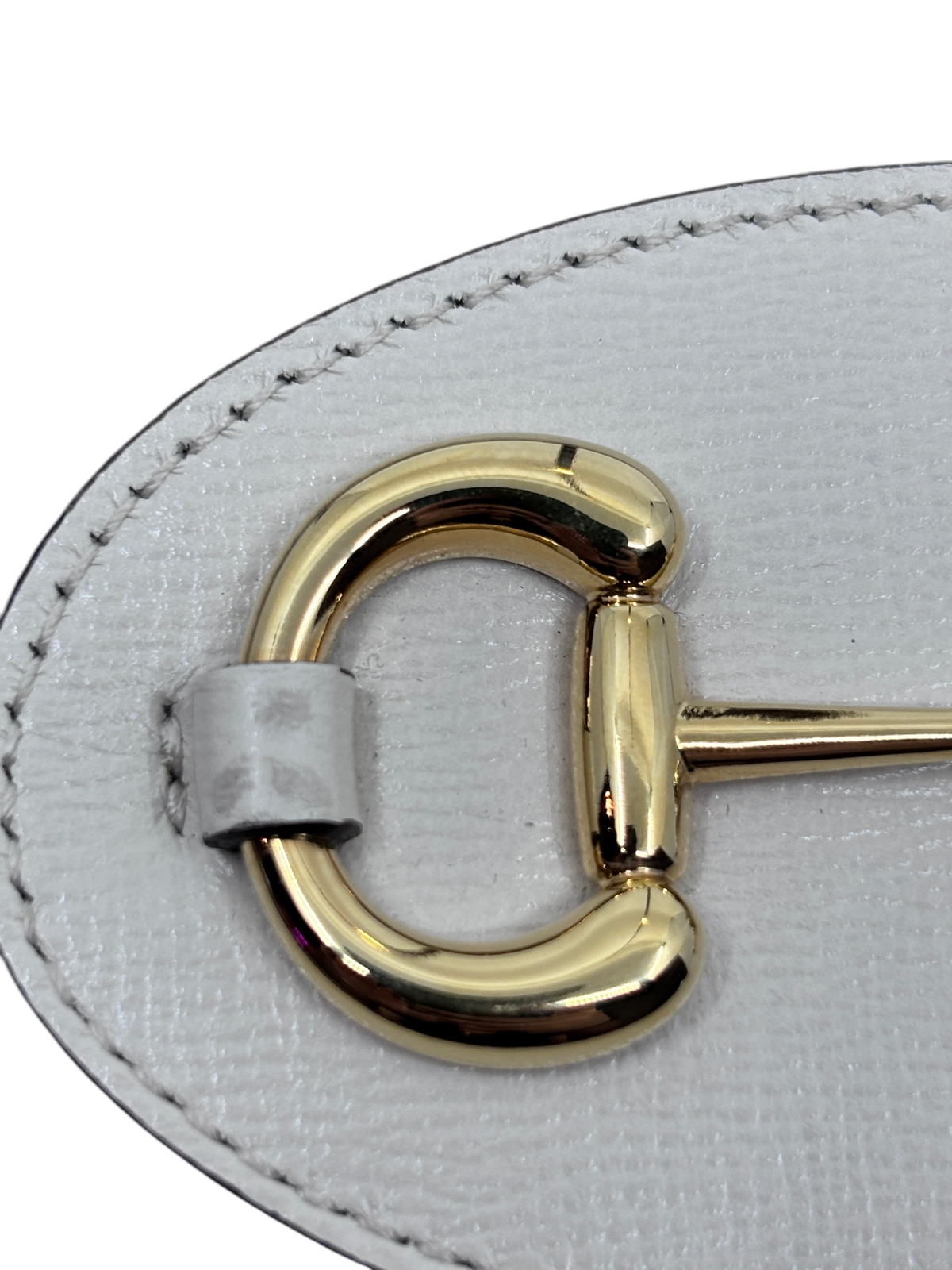 Posh Purse Co. Gucci Horsebit 1955 bag detail featuring polished gold-tone hardware on white textured leather.