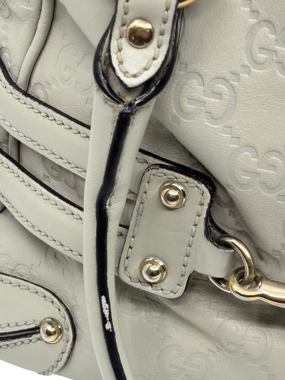 Close-up of a preloved Posh Purse Co Gucci Horsebit Wave bag in off-white embossed leather with gold hardware details.