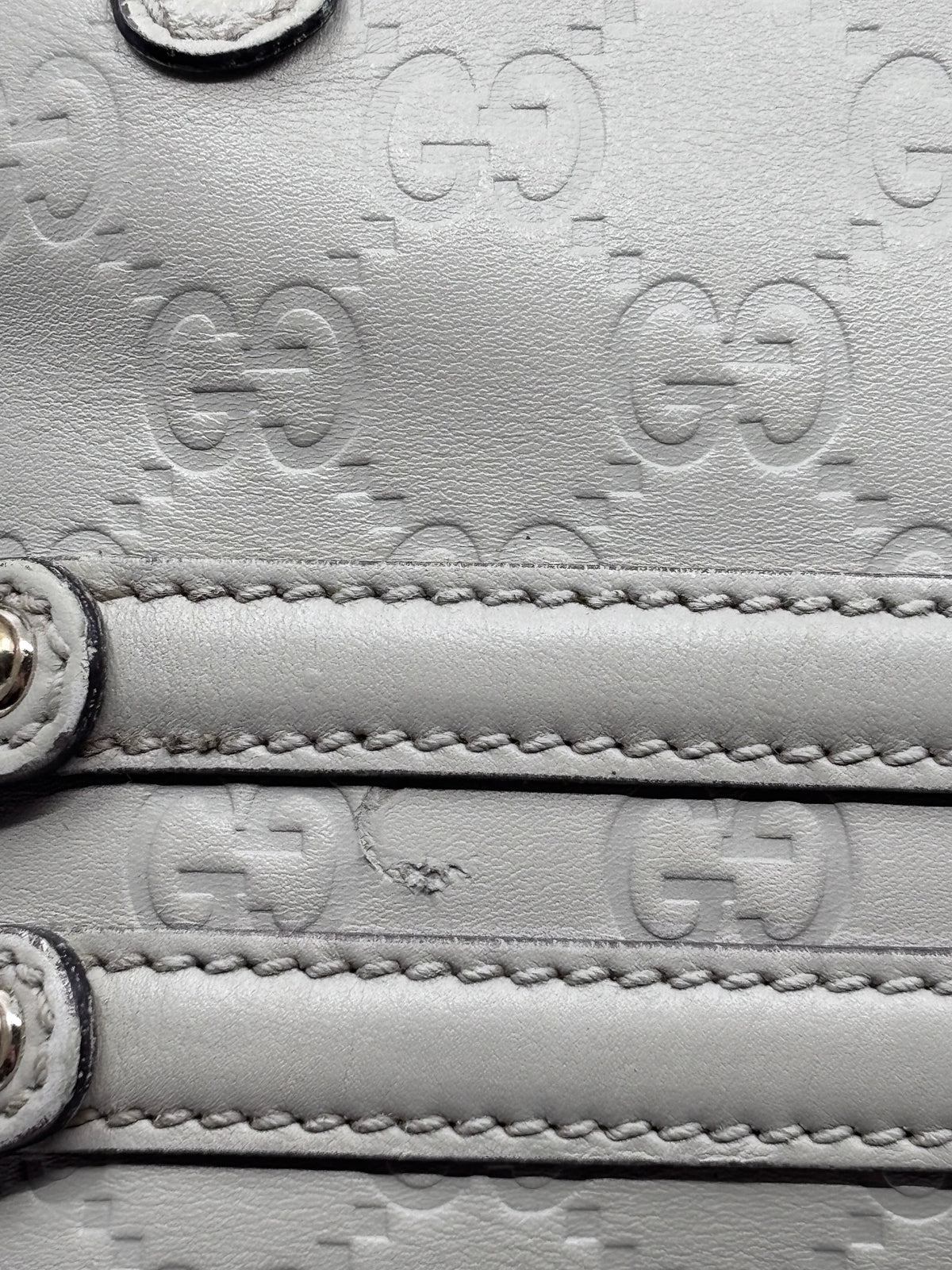 Close-up of grey embossed leather on a Posh Purse Co preloved Gucci Horsebit Wave bag showing signature GG pattern