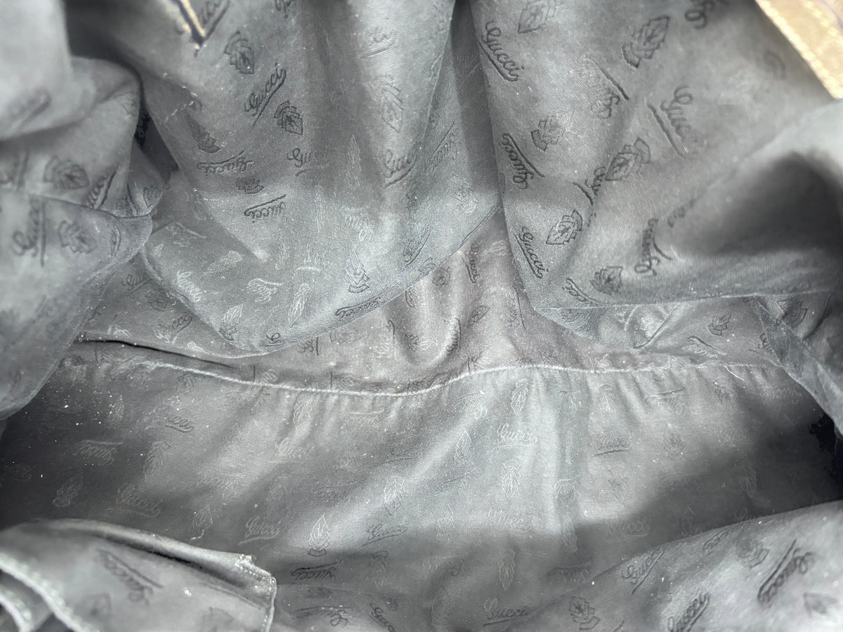 Interior of a gray Posh Purse Co. Gucci Jockey shoulder bag featuring the signature monogram fabric lining
