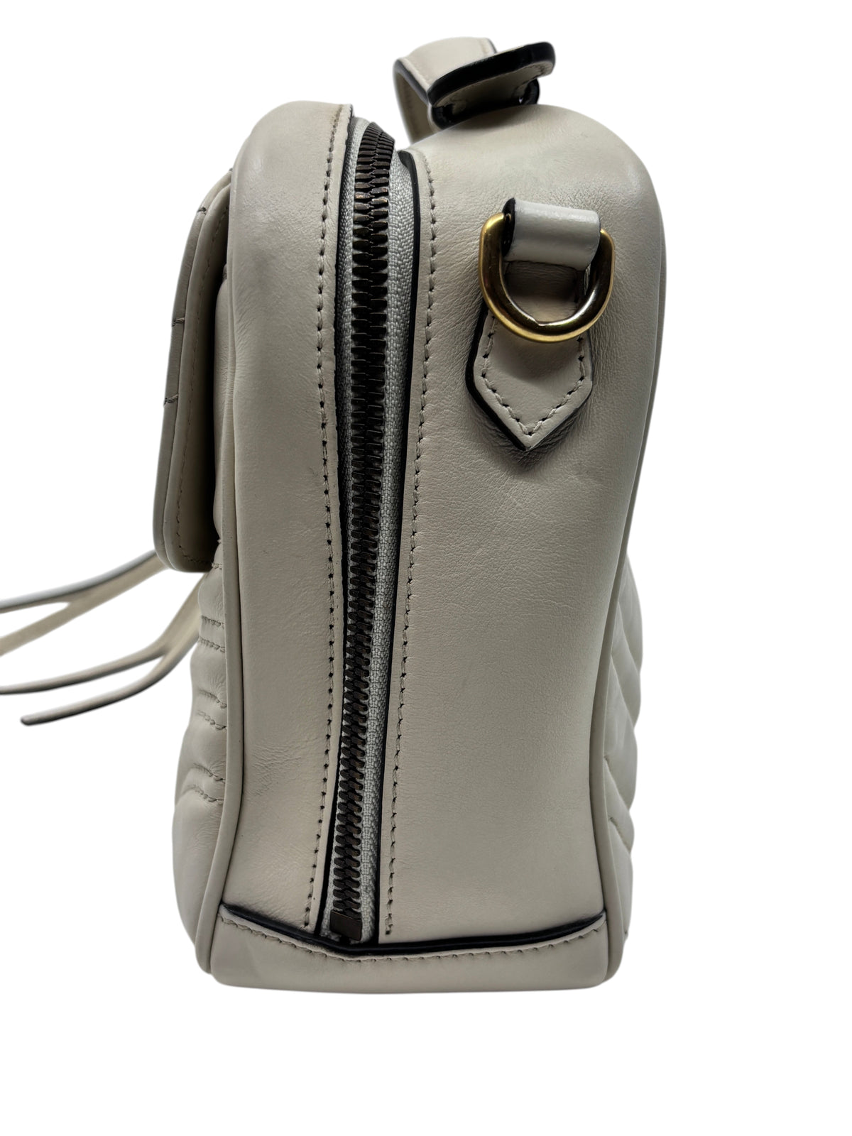 Side view of a beige Posh Purse Co Gucci GG Marmont quilted leather camera bag with gold hardware