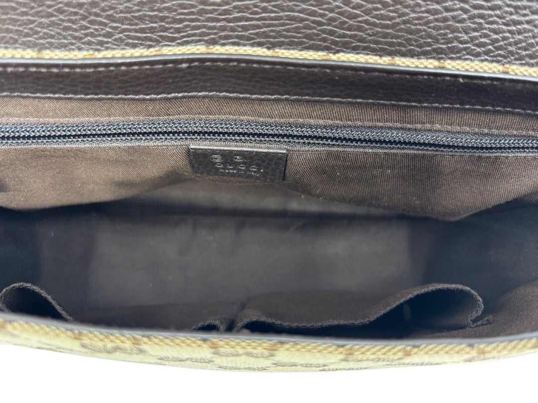 Interior of a Posh Purse Co. preloved Gucci GG monogram messenger bag with brown fabric lining and zip pocket.