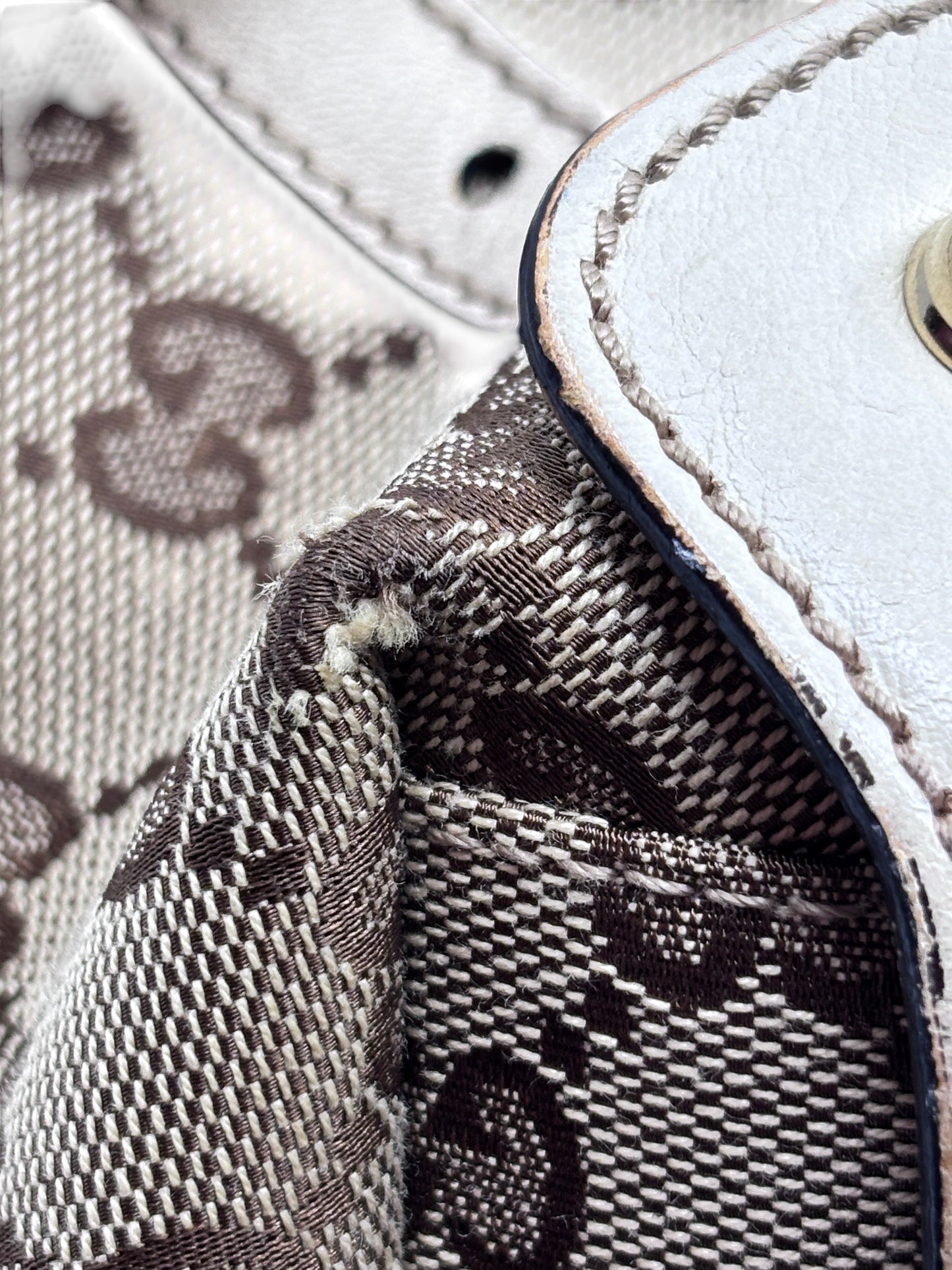 Posh Purse Co preloved Gucci Pelham handbag showing close-up of monogram canvas corner wear and white leather trim