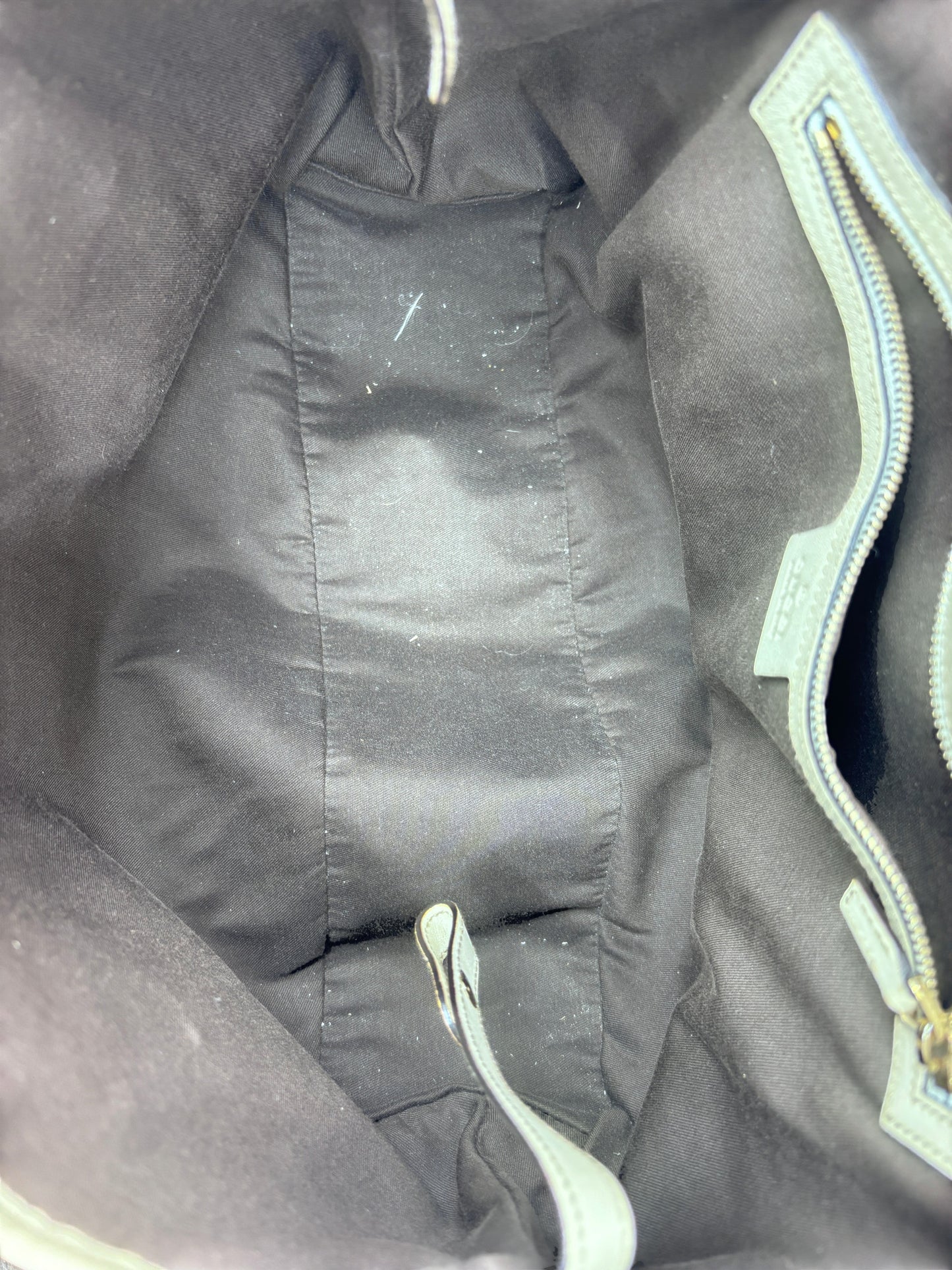 Interior of a Posh Purse Co preloved Gucci Pelham handbag featuring dark fabric lining and a zippered side pocket.