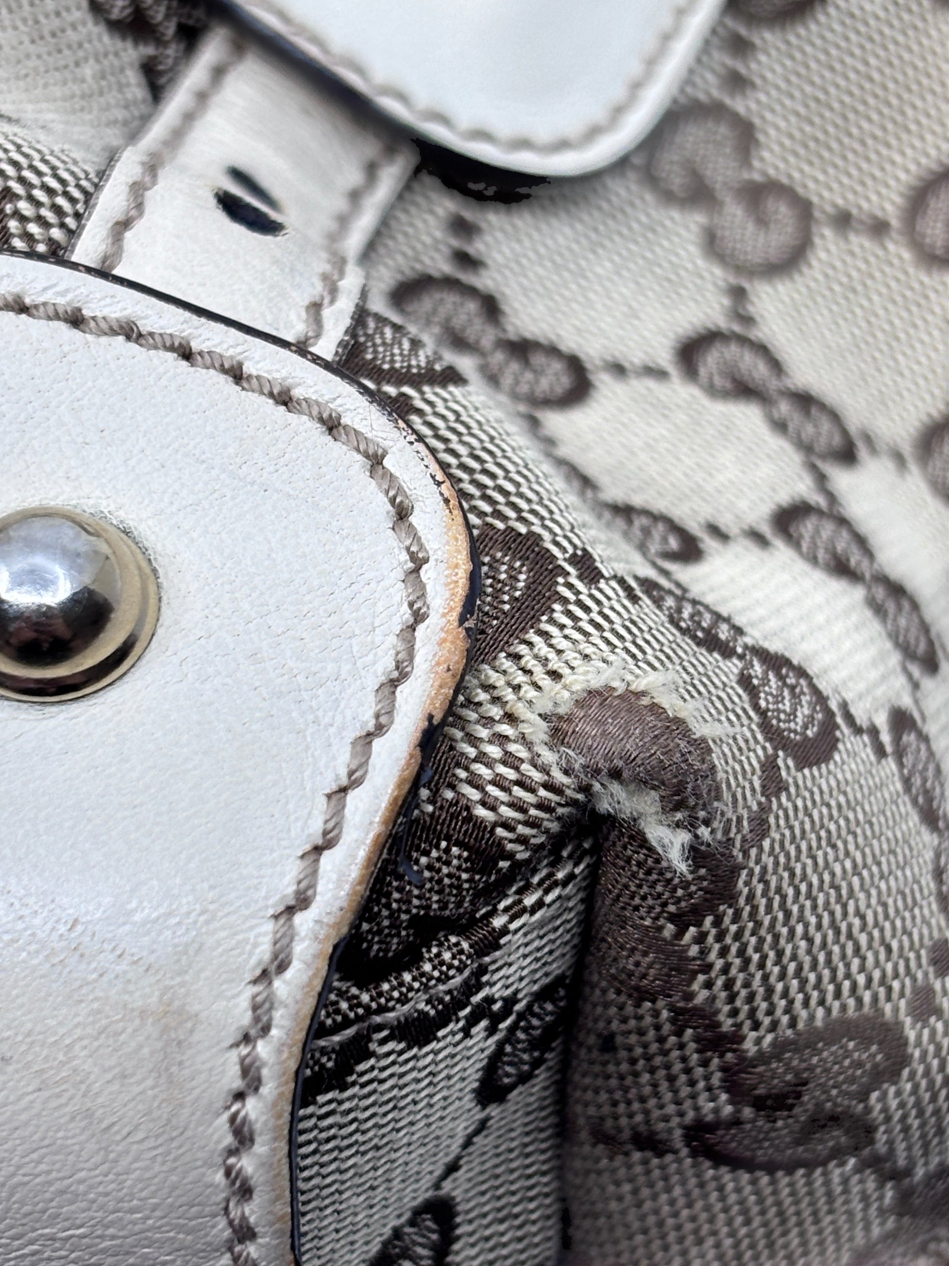 Close-up of Posh Purse Co preloved Gucci Pelham handbag showing monogram canvas, white leather trim, and corner wear.