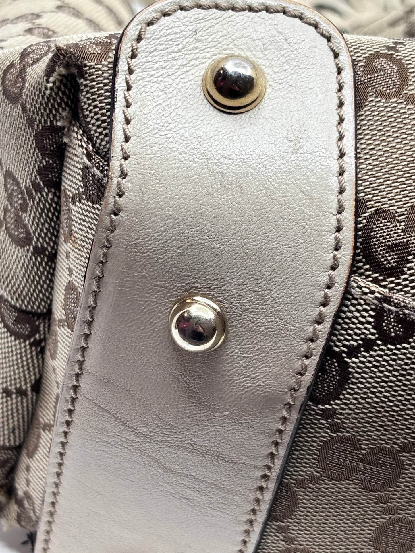 Close-up of Posh Purse Co preloved Gucci Pelham handbag featuring signature monogram canvas and metallic leather trim