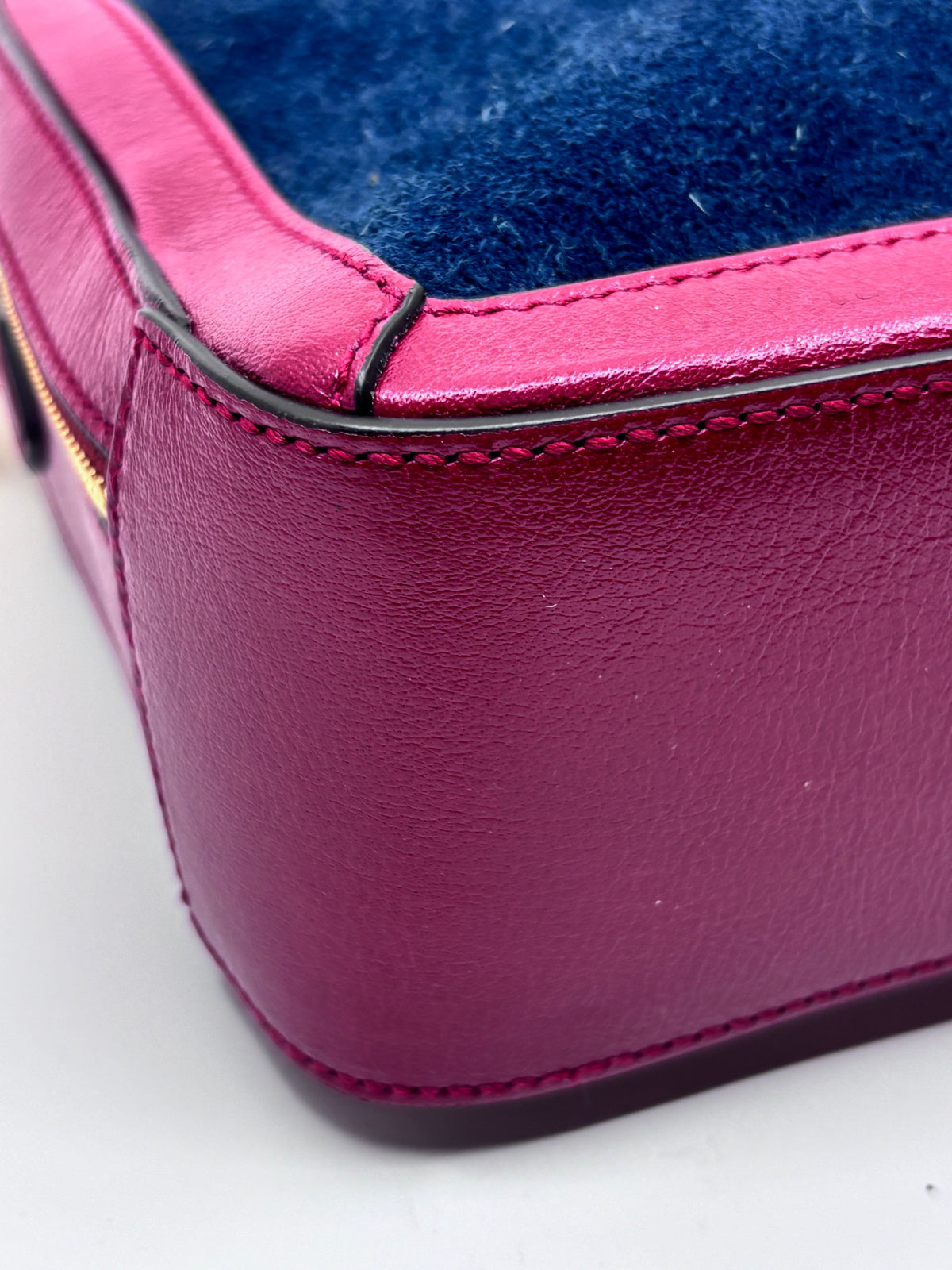 Close-up of Posh Purse Co preloved Gucci camera bag in red leather and blue suede with visible stitching detail
