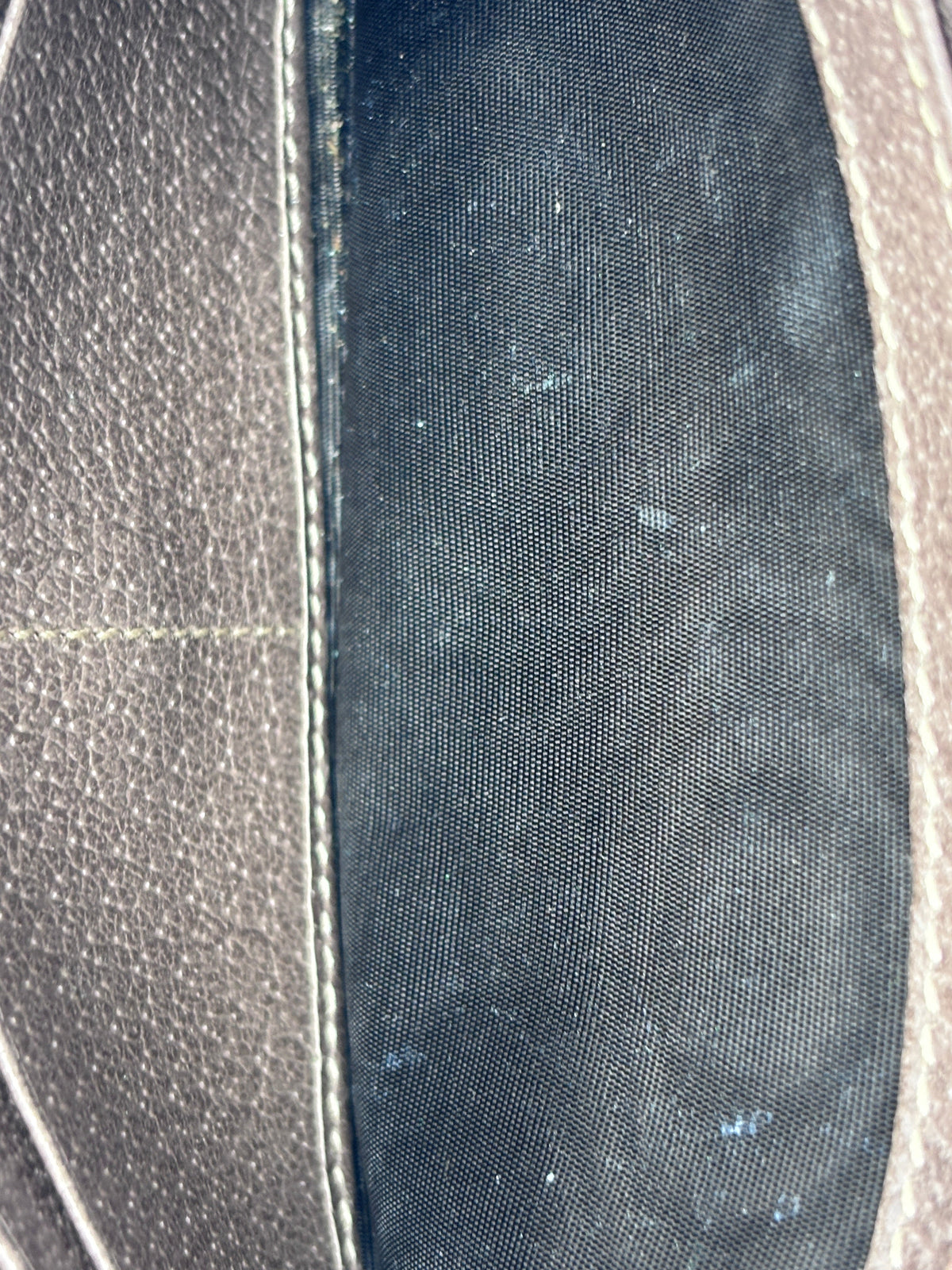Interior lining of a Posh Purse Co. preloved Gucci wallet on chain showing black fabric with minor staining