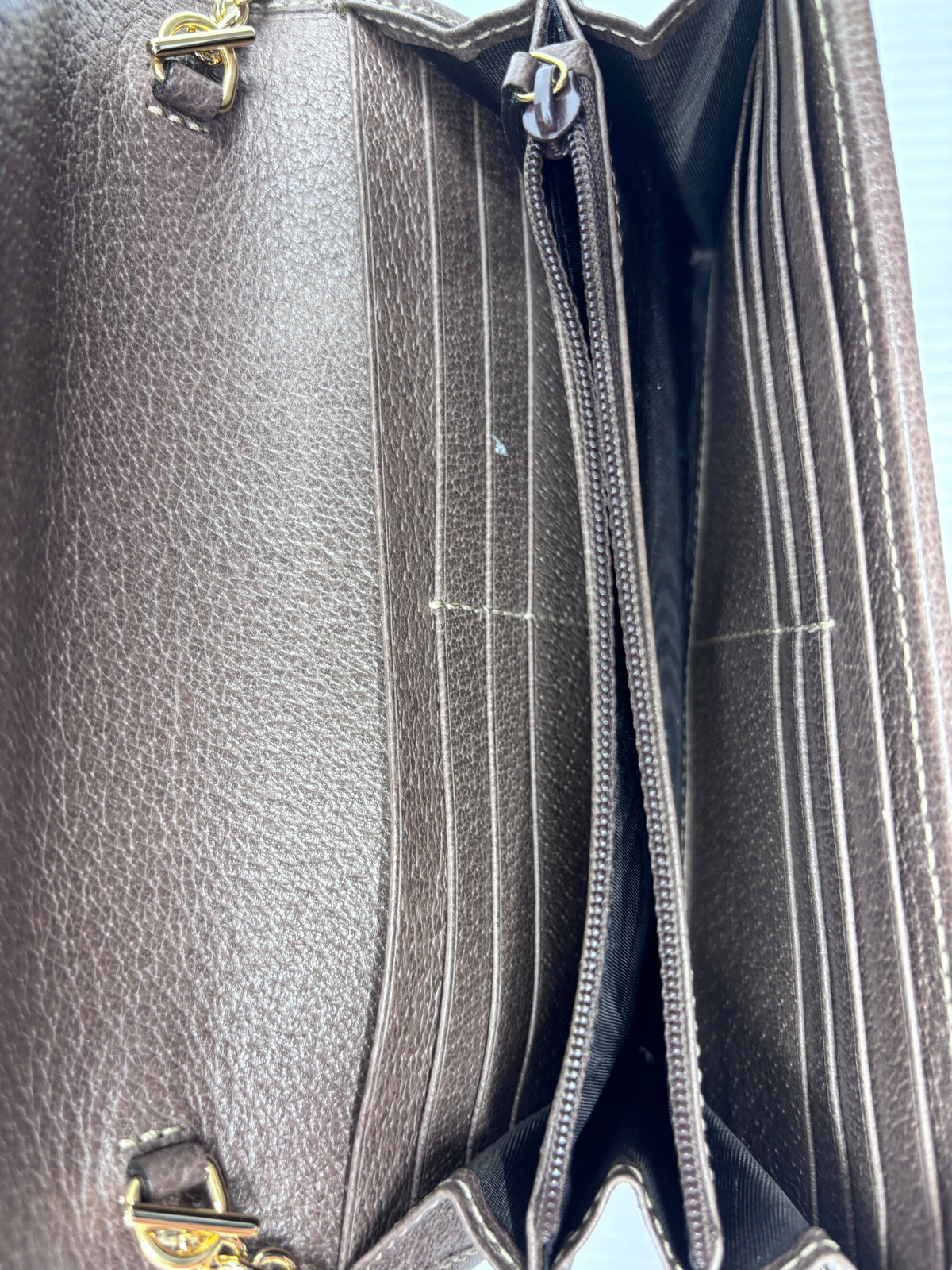 Interior of a Posh Purse Co. preloved Gucci wallet on chain featuring brown leather card slots and a zipper pocket.