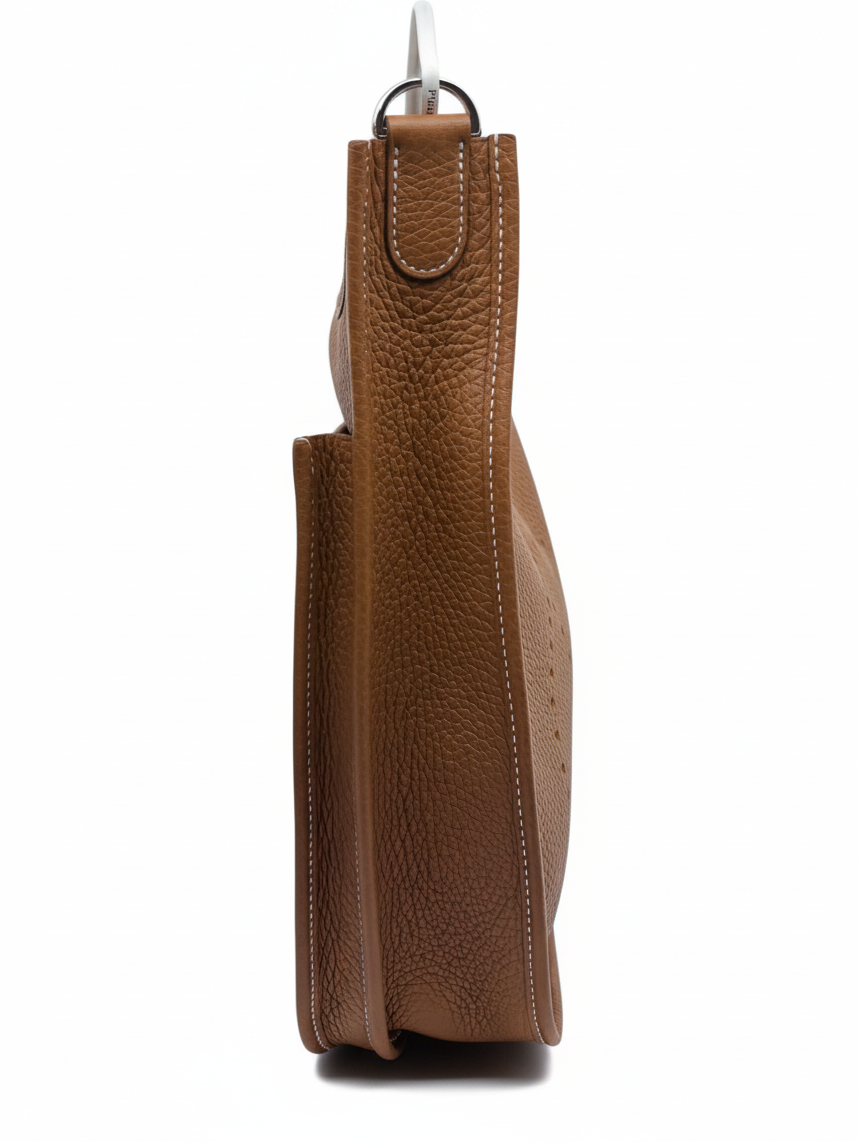 Posh Purse Co brand new Hermès Evelyne bag in gold leather with side view showing pebbled texture and white stitching