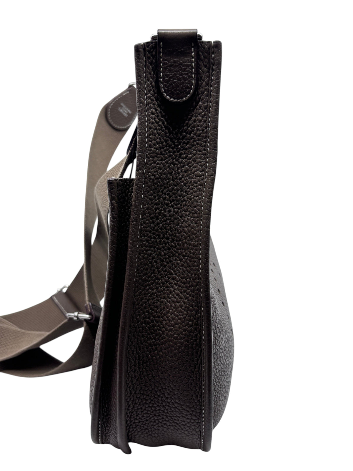 Side view of a Posh Purse Co. preloved Hermès Evelyne PM bag in Etoupe Taurillon Clemence leather with shoulder strap.