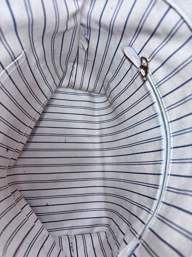 Interior of Posh Purse Co Louis Vuitton Bagatelle bag featuring striped fabric lining and a zippered pocket