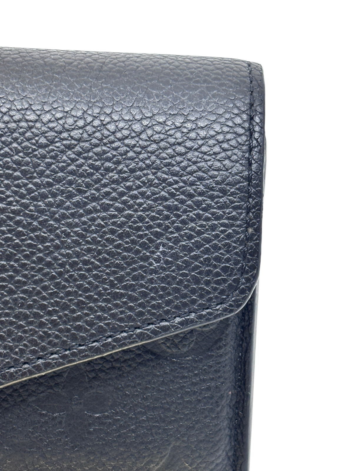 Close-up of black embossed Monogram Empreinte leather on a Posh Purse Co Louis Vuitton Sarah wallet flap
