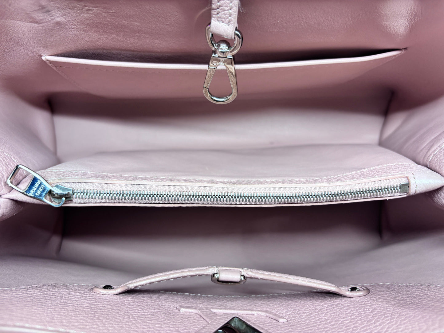 Interior view of a beige Louis Vuitton Capucines MM bag featuring a zippered pocket and silver hardware by Posh Purse Co
