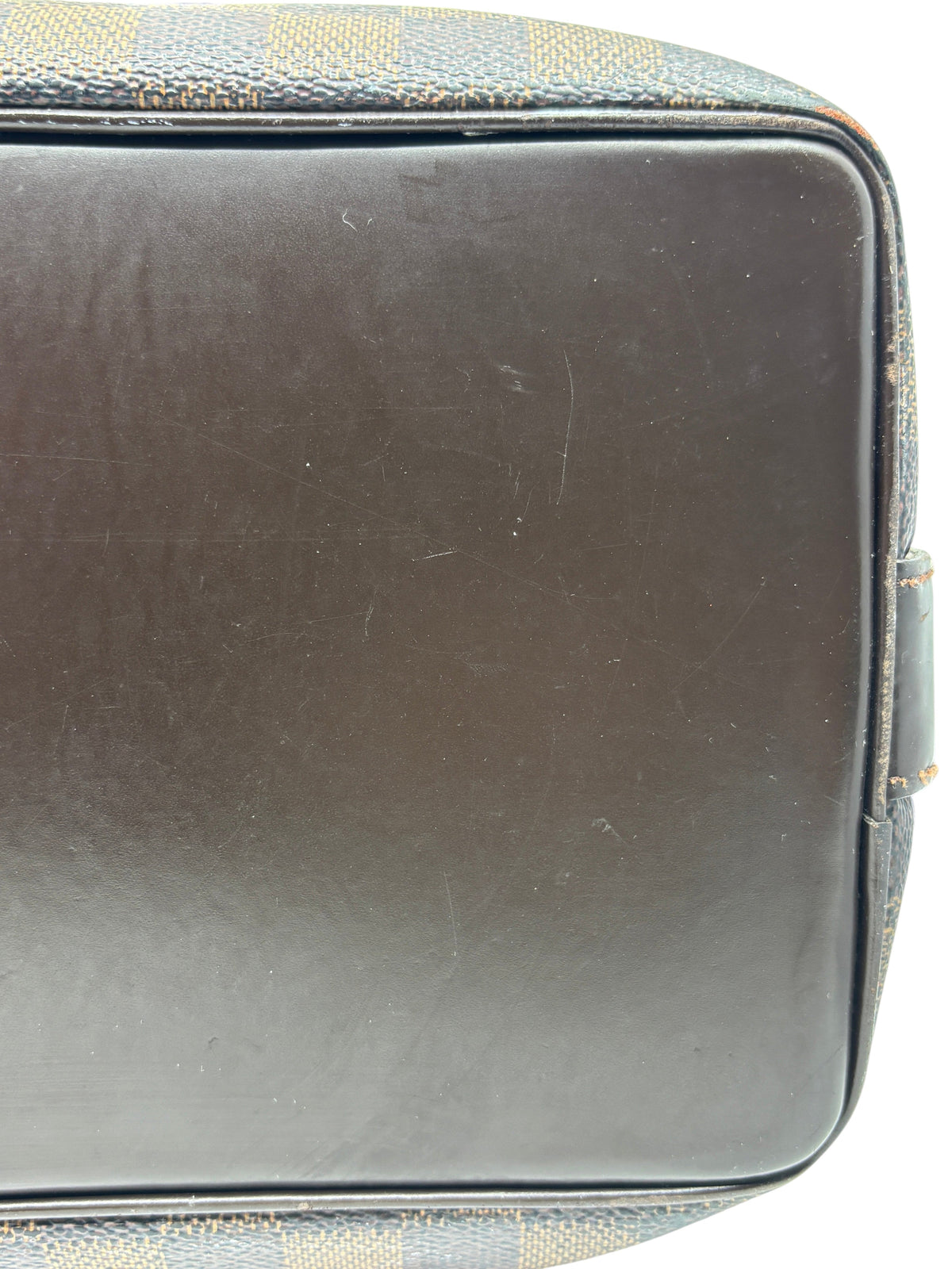 Close-up of the brown leather base of a Posh Purse Co. preloved Louis Vuitton Damier Ebene Chelsea Tote