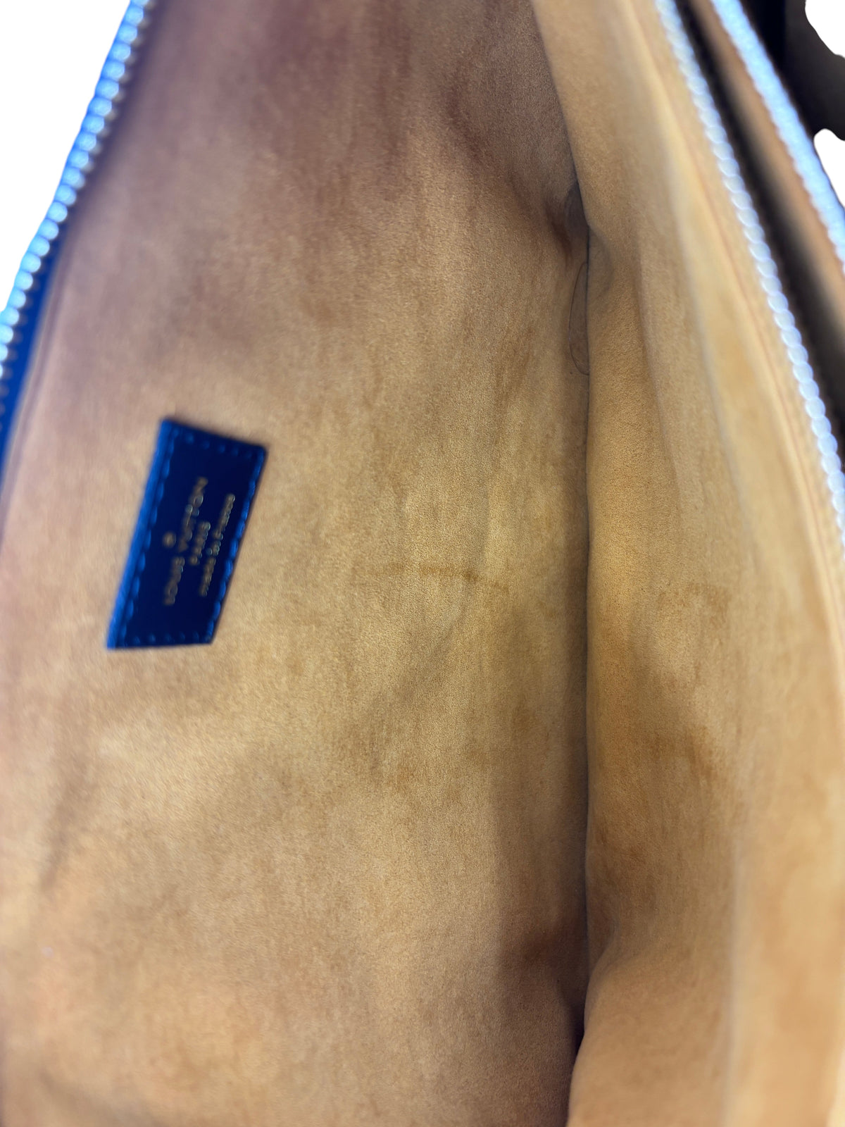 Interior of Posh Purse Co authentic black Louis Vuitton Coussin bag with tan suede lining and brand logo patch