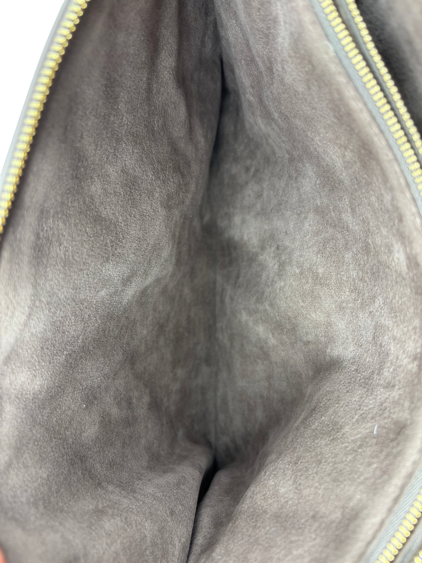Interior of Posh Purse Co grey Louis Vuitton Coussin Large handbag showing soft suede lining and gold zipper detail