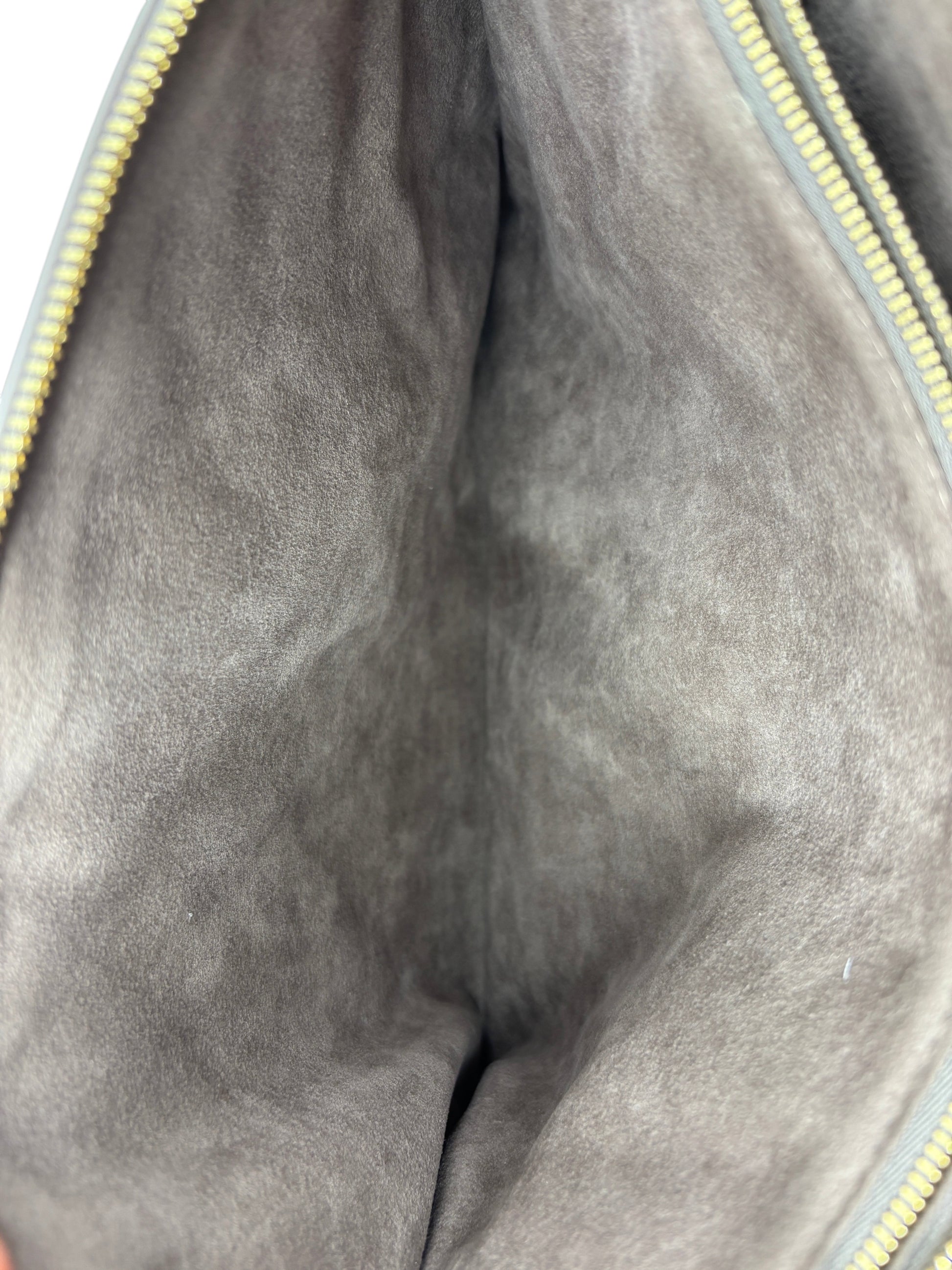 Interior of Posh Purse Co grey Louis Vuitton Coussin Large handbag showing soft suede lining and gold zipper detail