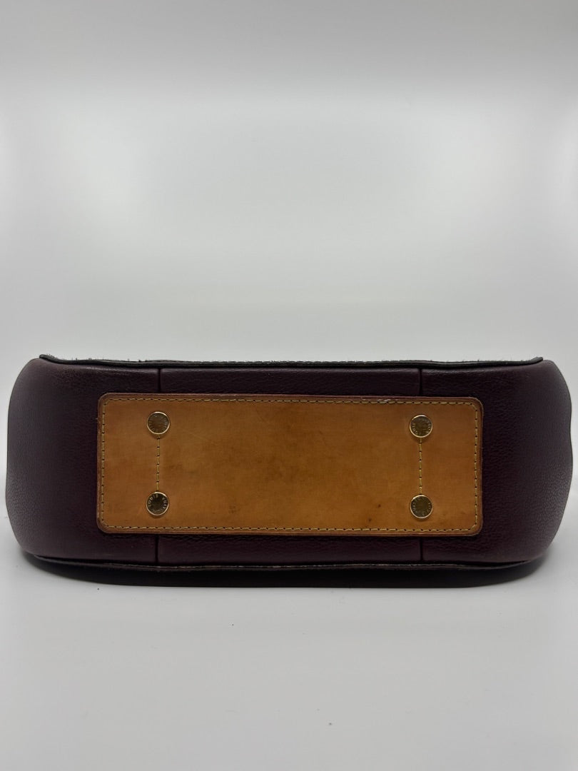 Base of preloved Louis Vuitton Eden MM bag from Posh Purse Co. featuring brown leather and gold-tone protective feet.