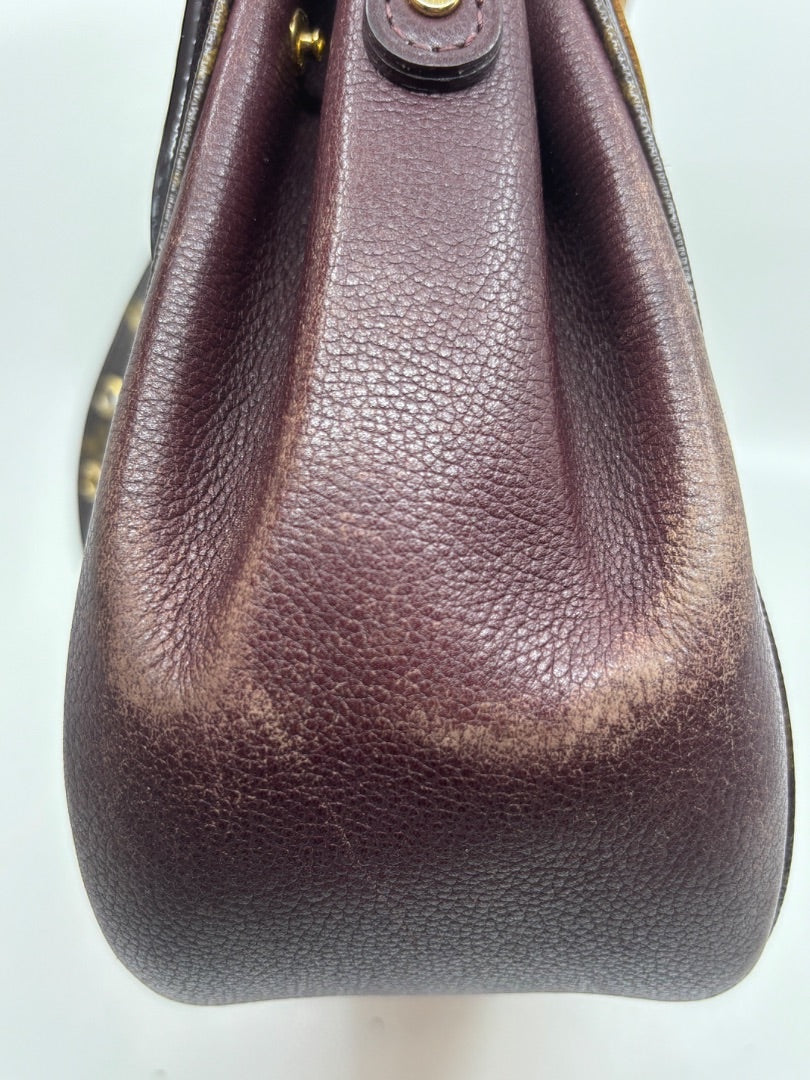 Side view of Posh Purse Co. preloved Louis Vuitton Eden MM bag featuring textured brown leather side panel.