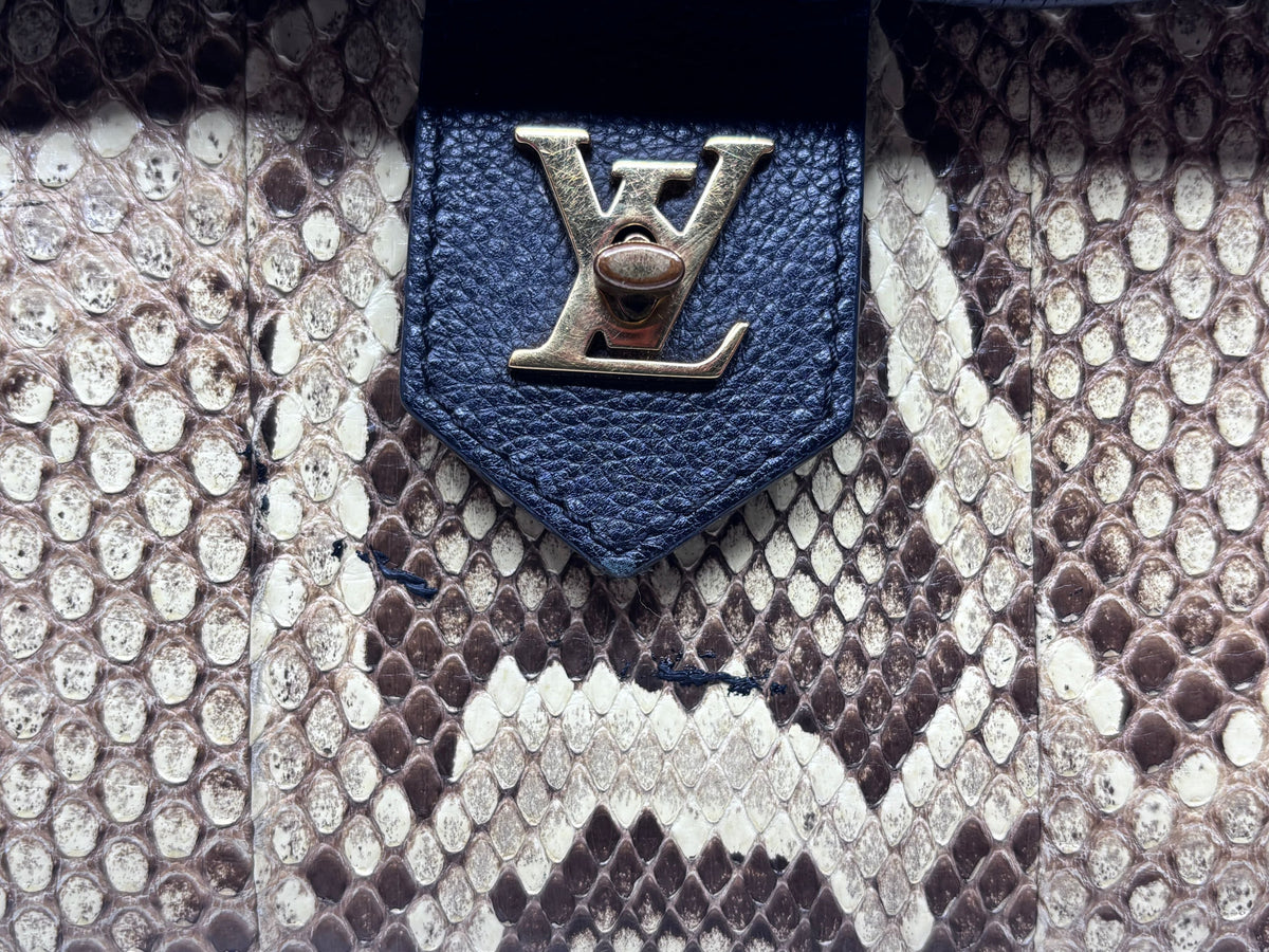 Posh Purse Co Louis Vuitton LockMe MM handbag featuring a gold LV turn-lock closure on genuine black and python skin