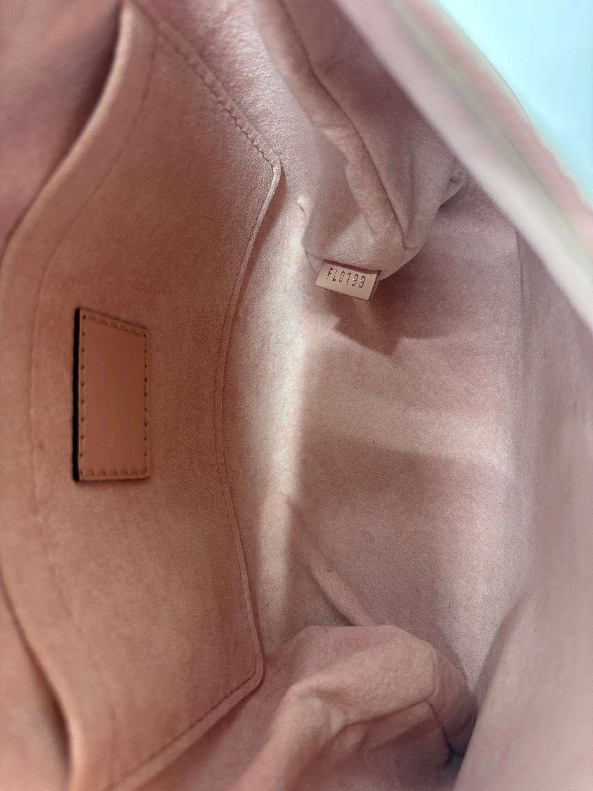 Interior of Posh Purse Co. preloved pink Louis Vuitton Locky handbag showing clean lining and date code tag