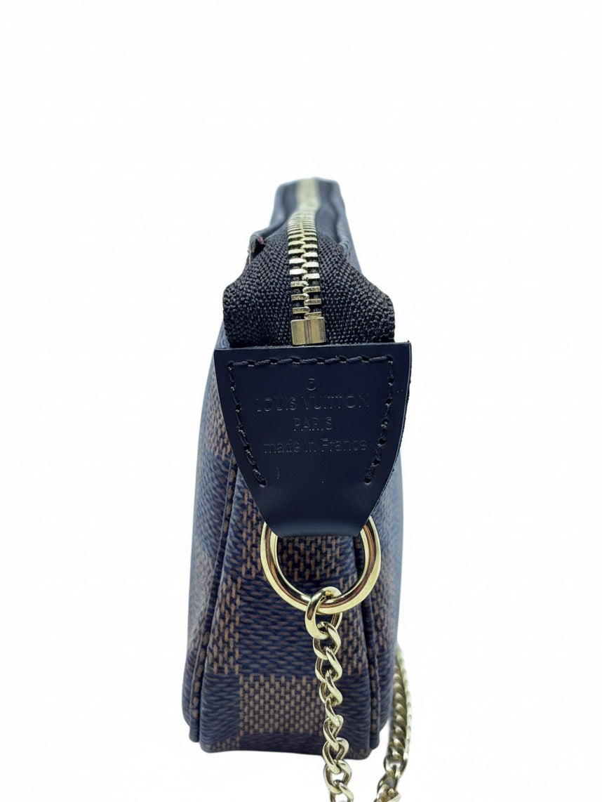 Posh Purse Co Louis Vuitton Damier Ebene Mini Pochette side view showing gold chain and leather tab detail