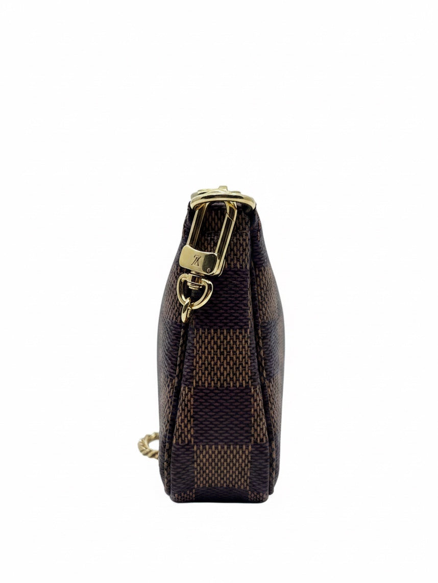 Side view of Posh Purse Co Louis Vuitton Damier Ebene Mini Pochette with gold-tone hardware and chain strap