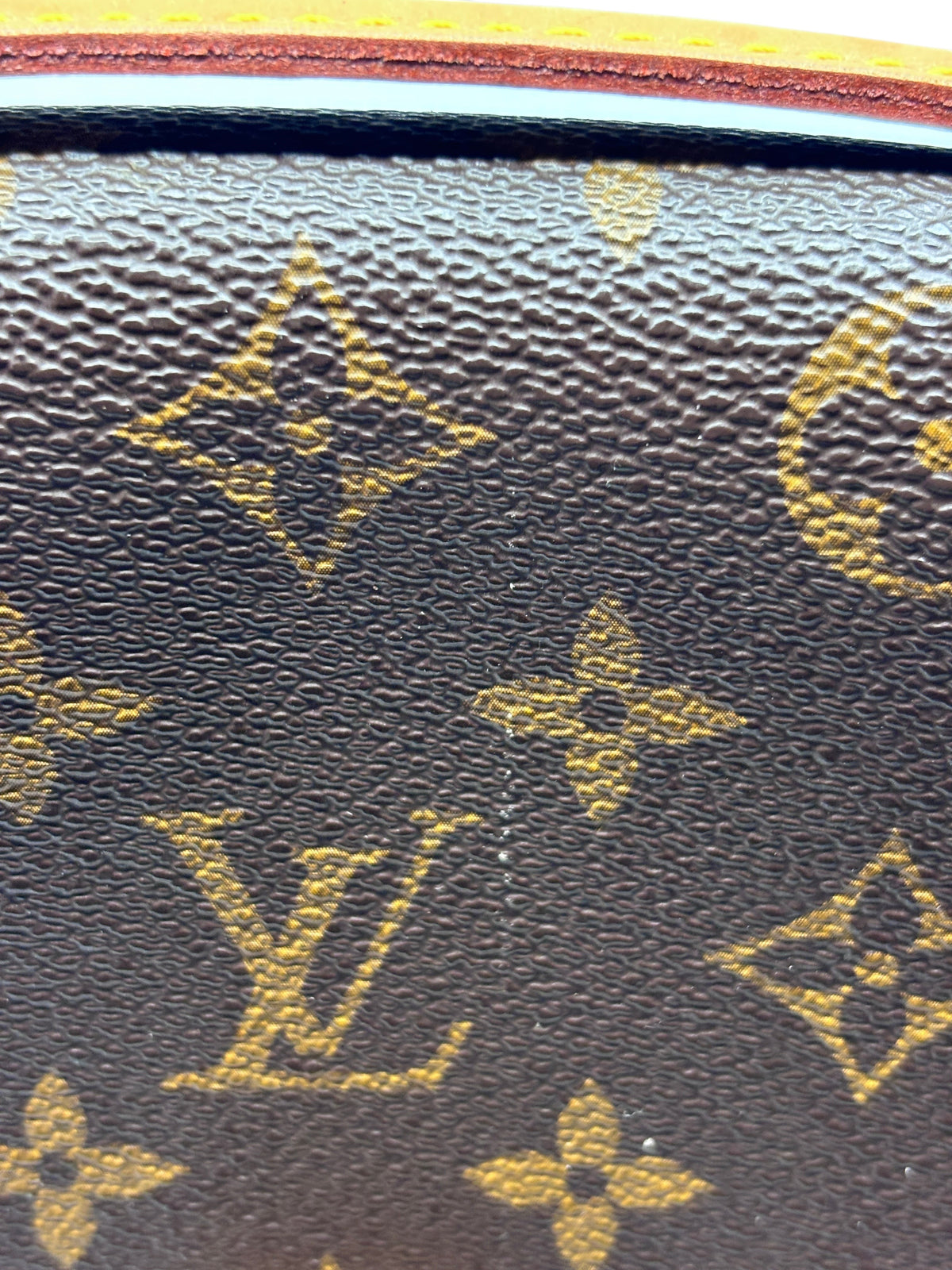Close-up of Posh Purse Co Louis Vuitton Monogram coated canvas texture with iconic brown and gold floral pattern.
