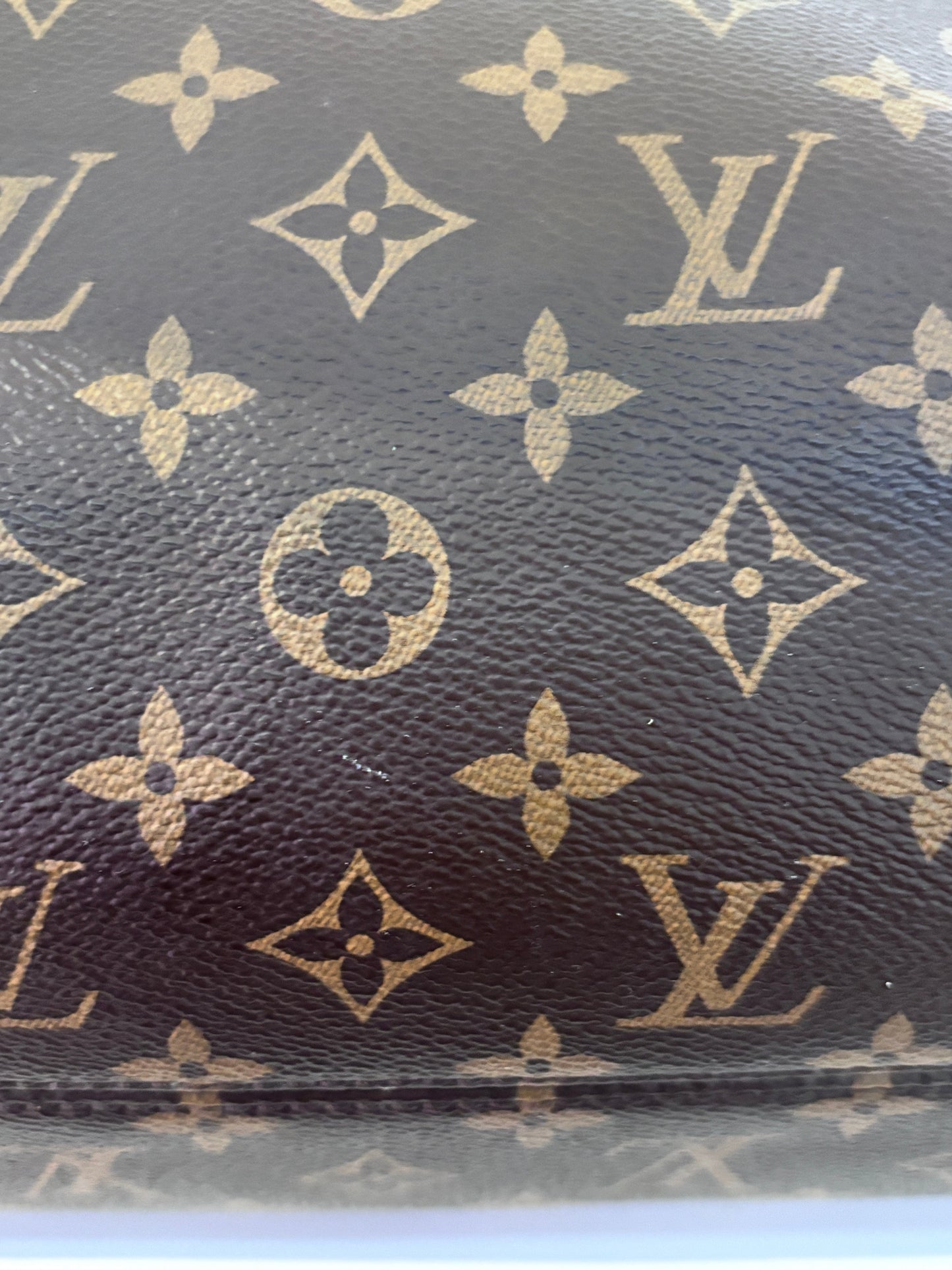 Close-up of Posh Purse Co preloved Louis Vuitton Monogram canvas featuring the iconic brown and gold floral pattern