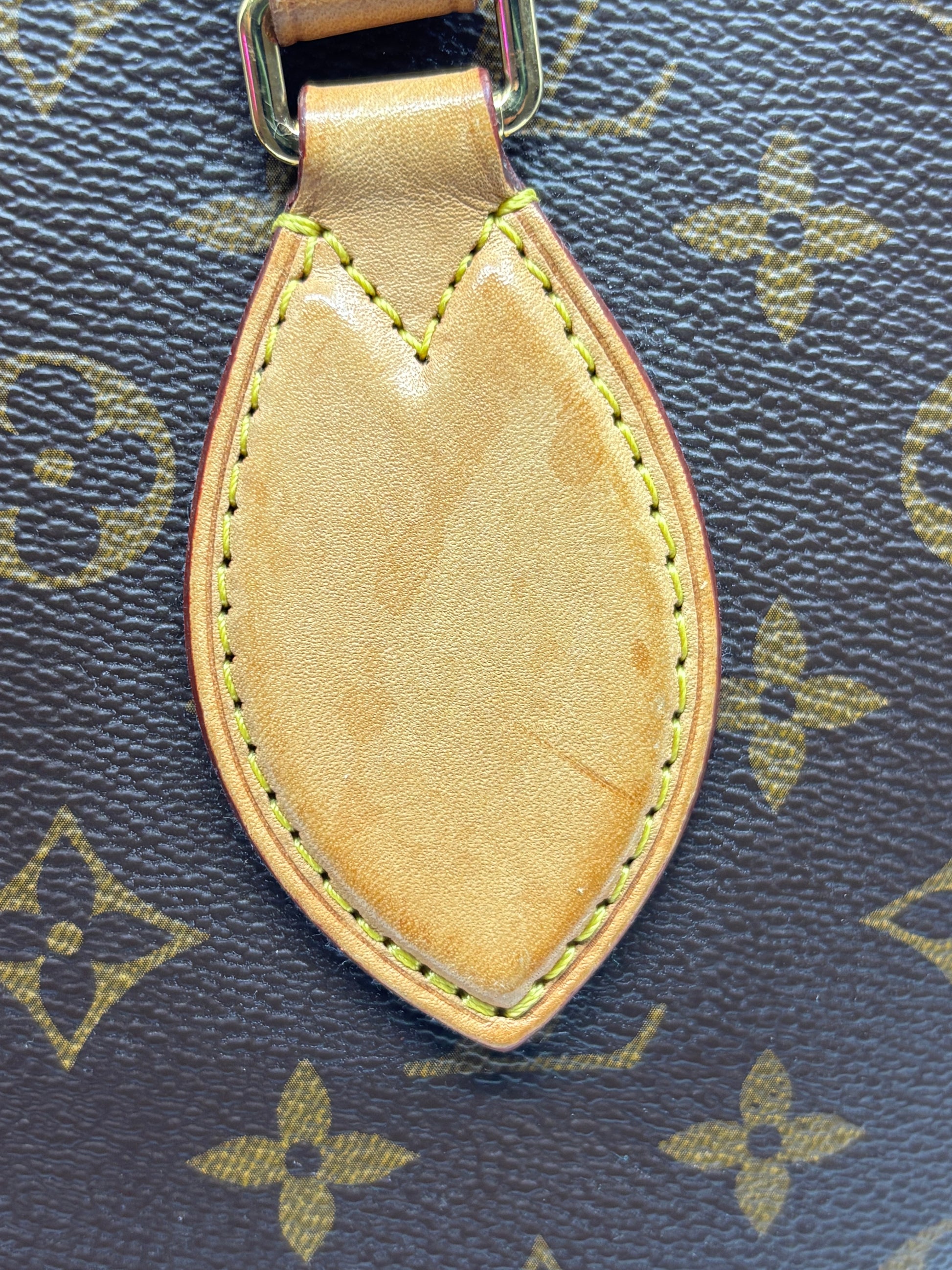 Posh Purse Co. Louis Vuitton Monogram canvas handbag featuring a signature petal-shaped tan leather luggage tag detail.
