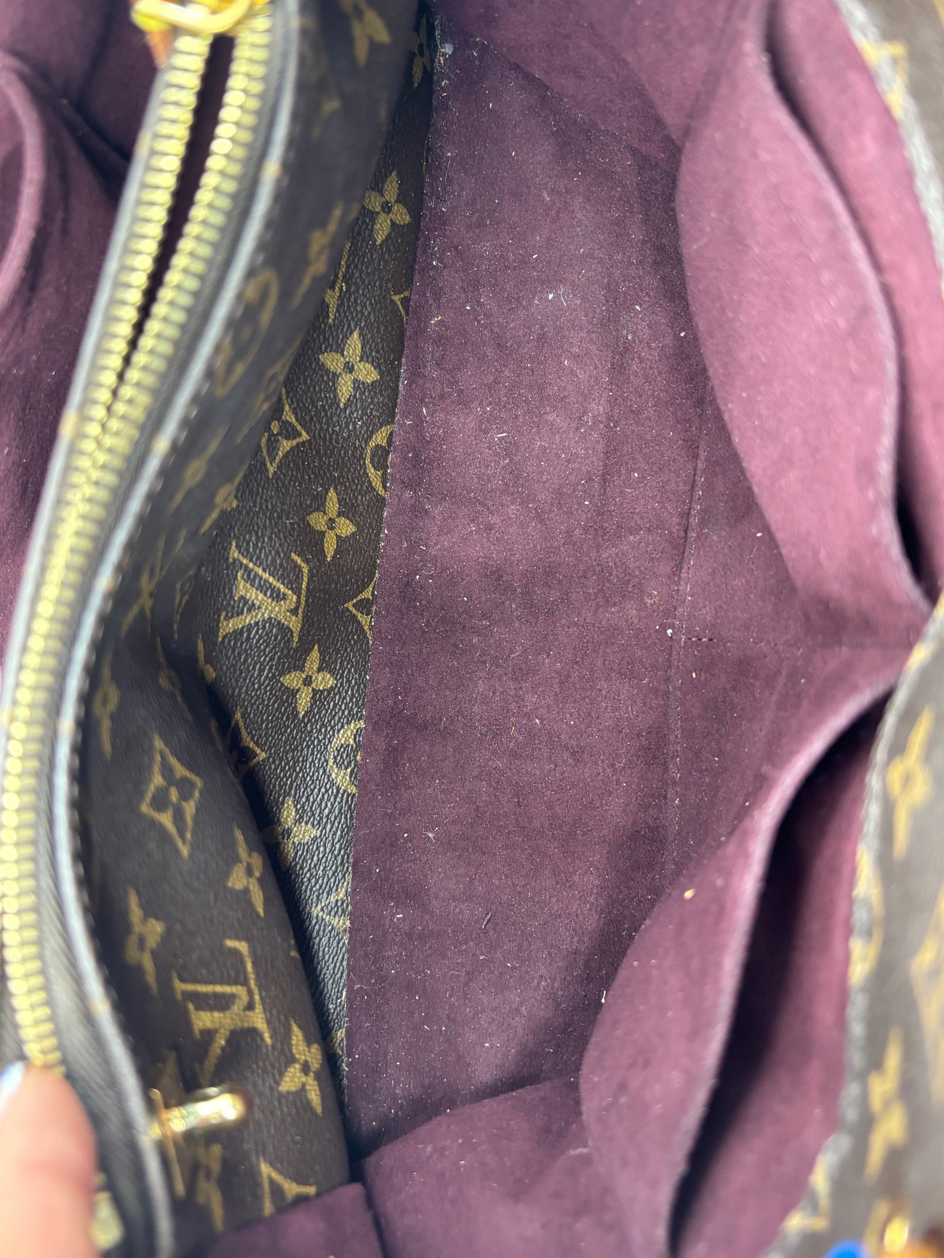 Posh Purse Co. Louis Vuitton Montaigne MM interior featuring dark purple suede lining and monogram canvas compartments.