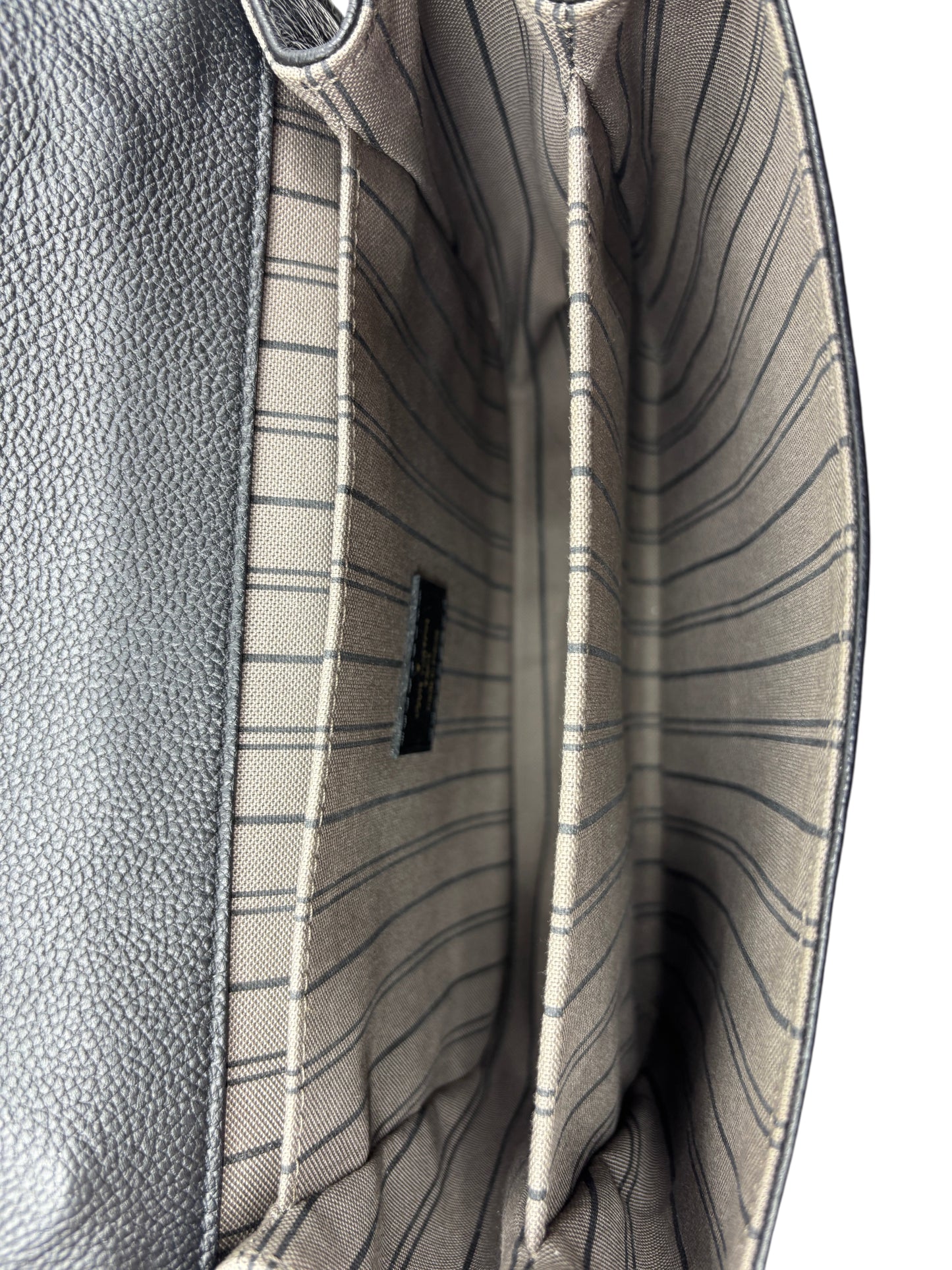 Interior of Posh Purse Co Louis Vuitton Empreinte Pochette Metis bag showing striped fabric lining and compartments.