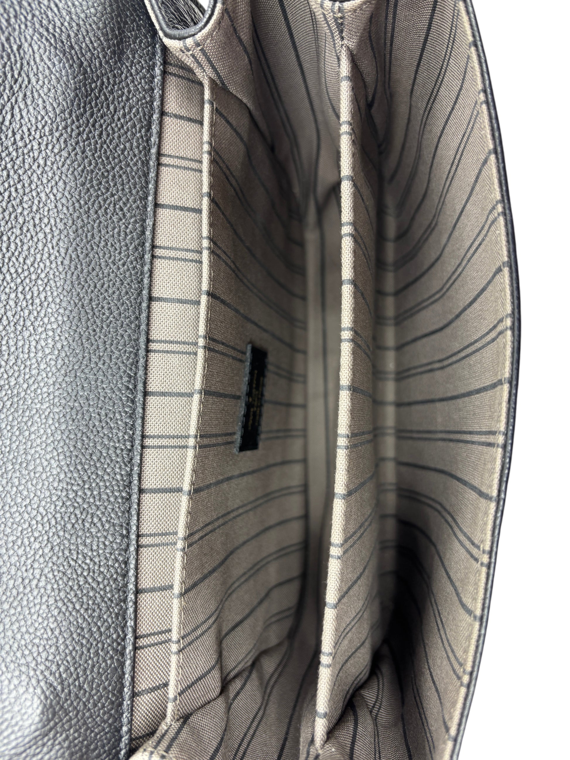 Interior of Posh Purse Co Louis Vuitton Empreinte Pochette Metis bag showing striped fabric lining and compartments.