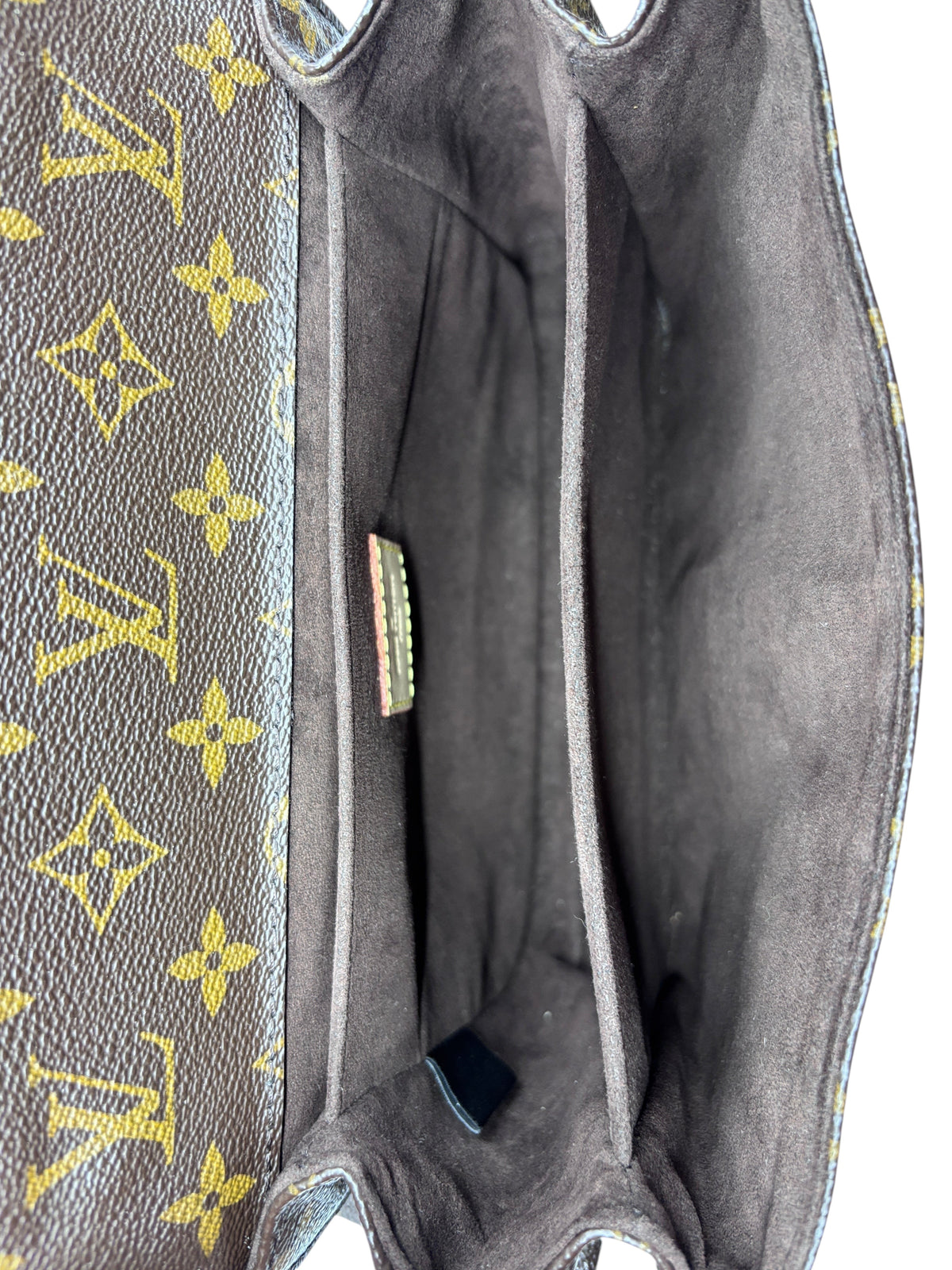 Interior view of Posh Purse Co Louis Vuitton Monogram Pochette Metis handbag showing brown fabric lining and pockets