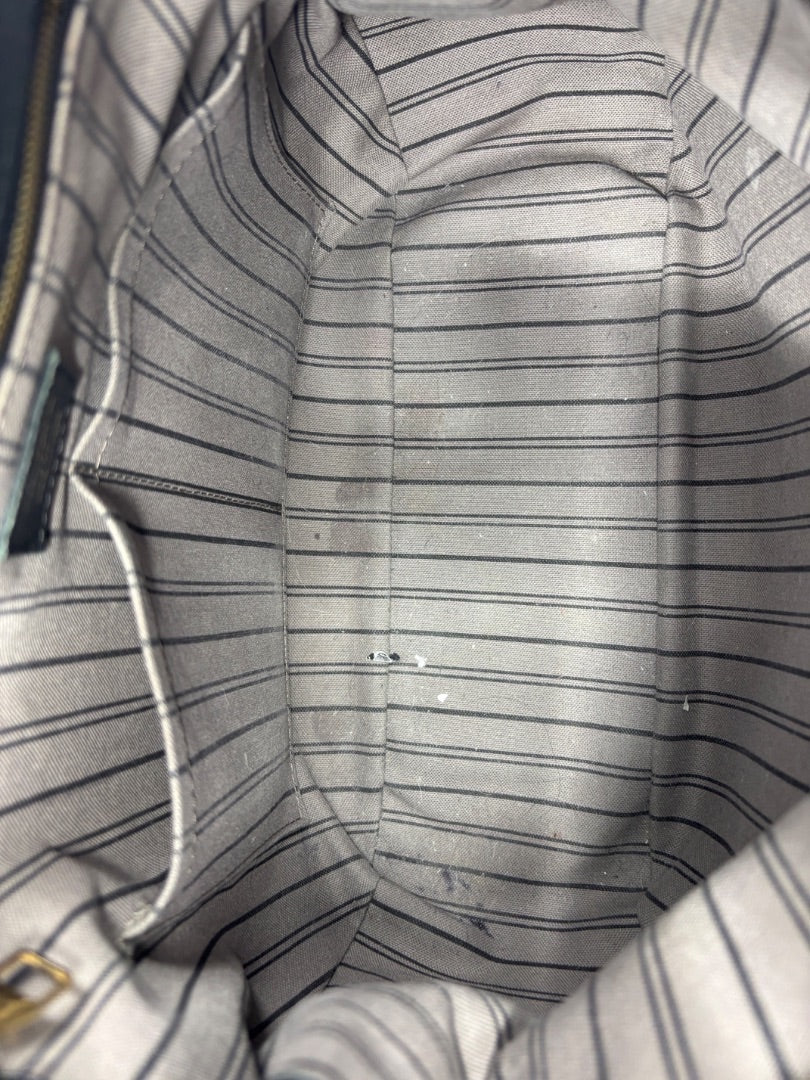 Interior of Posh Purse Co. preloved Louis Vuitton Spontini bag with grey and black striped fabric lining.