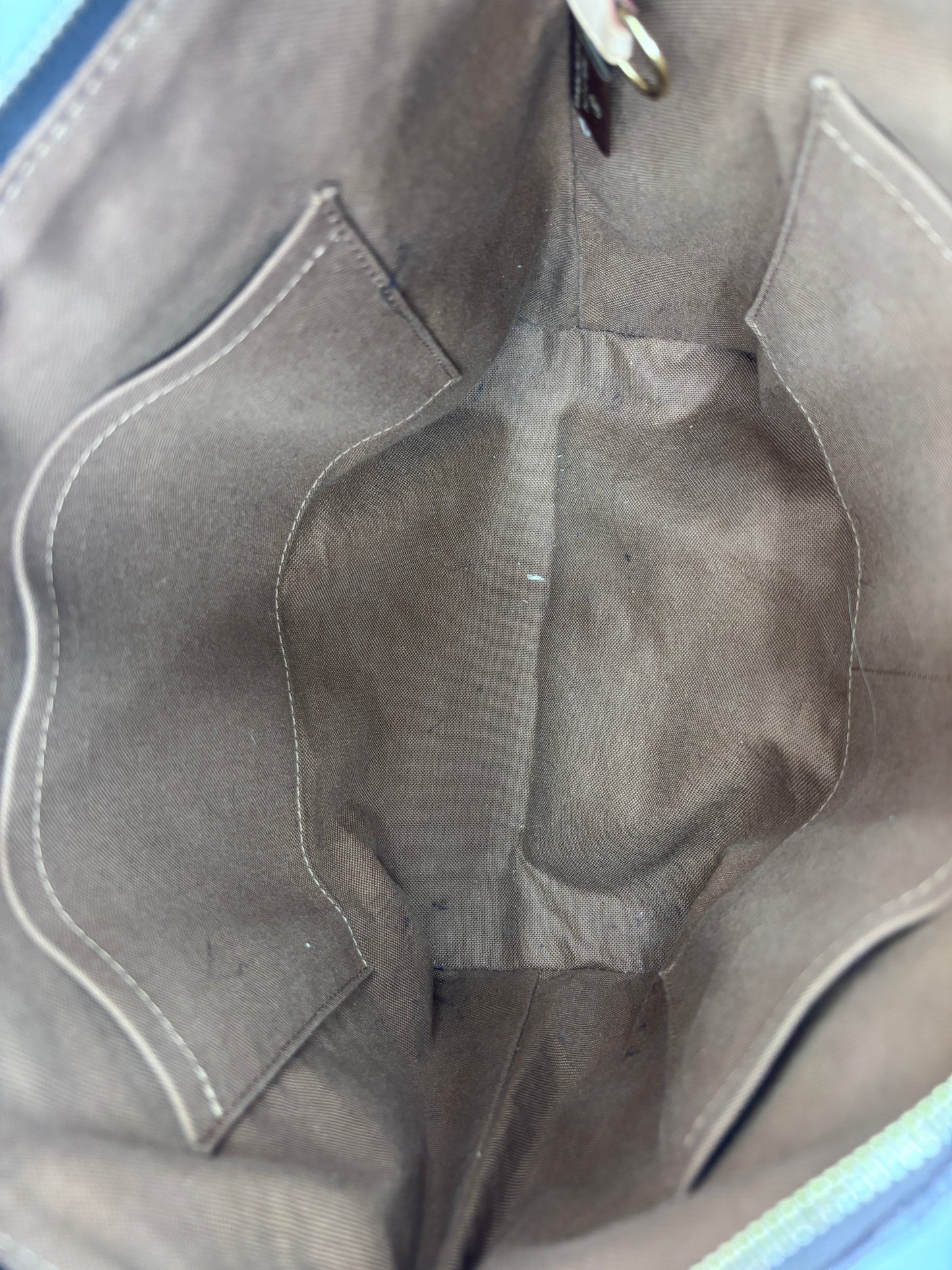 Interior of Posh Purse Co preowned Louis Vuitton Totally PM tote bag featuring clean brown fabric lining and pockets