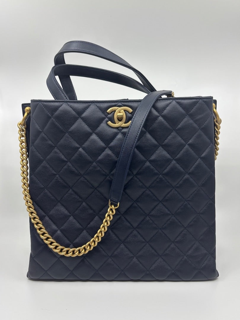 Posh Purse Co. navy blue quilted leather Chanel tote bag with gold hardware and chain strap.